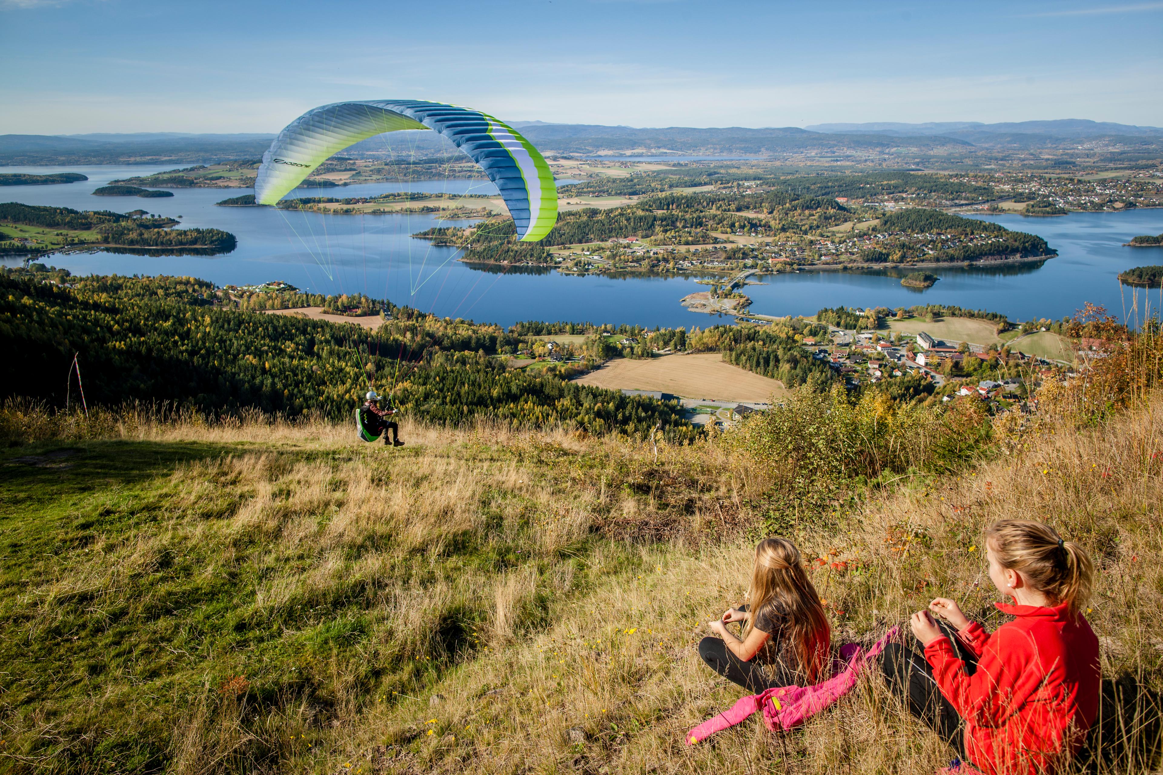 Two kids enjoying a paraglider from the the King's View in Ringerike in Eastern Norway