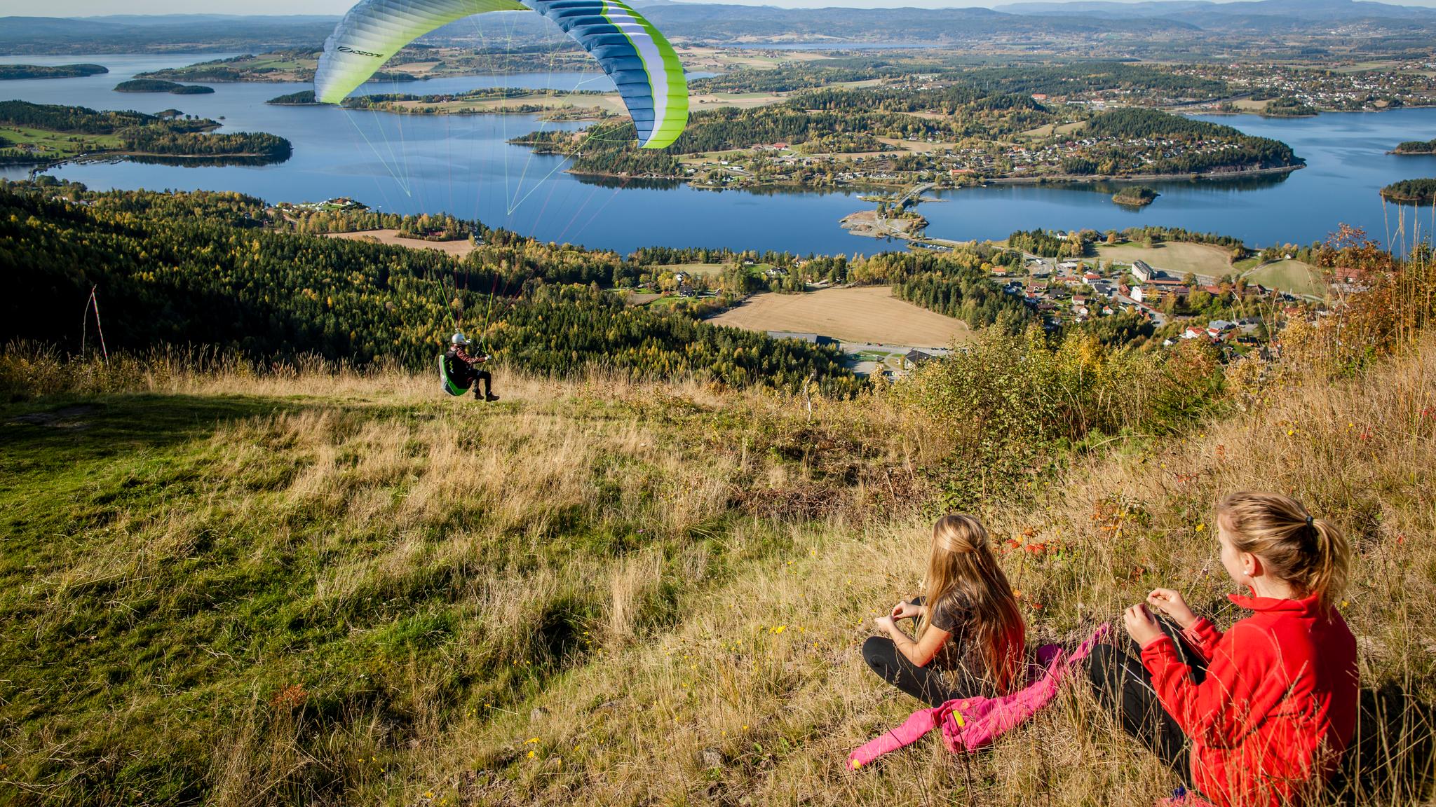 Two kids enjoying a paraglider from the the King's View in Ringerike in Eastern Norway