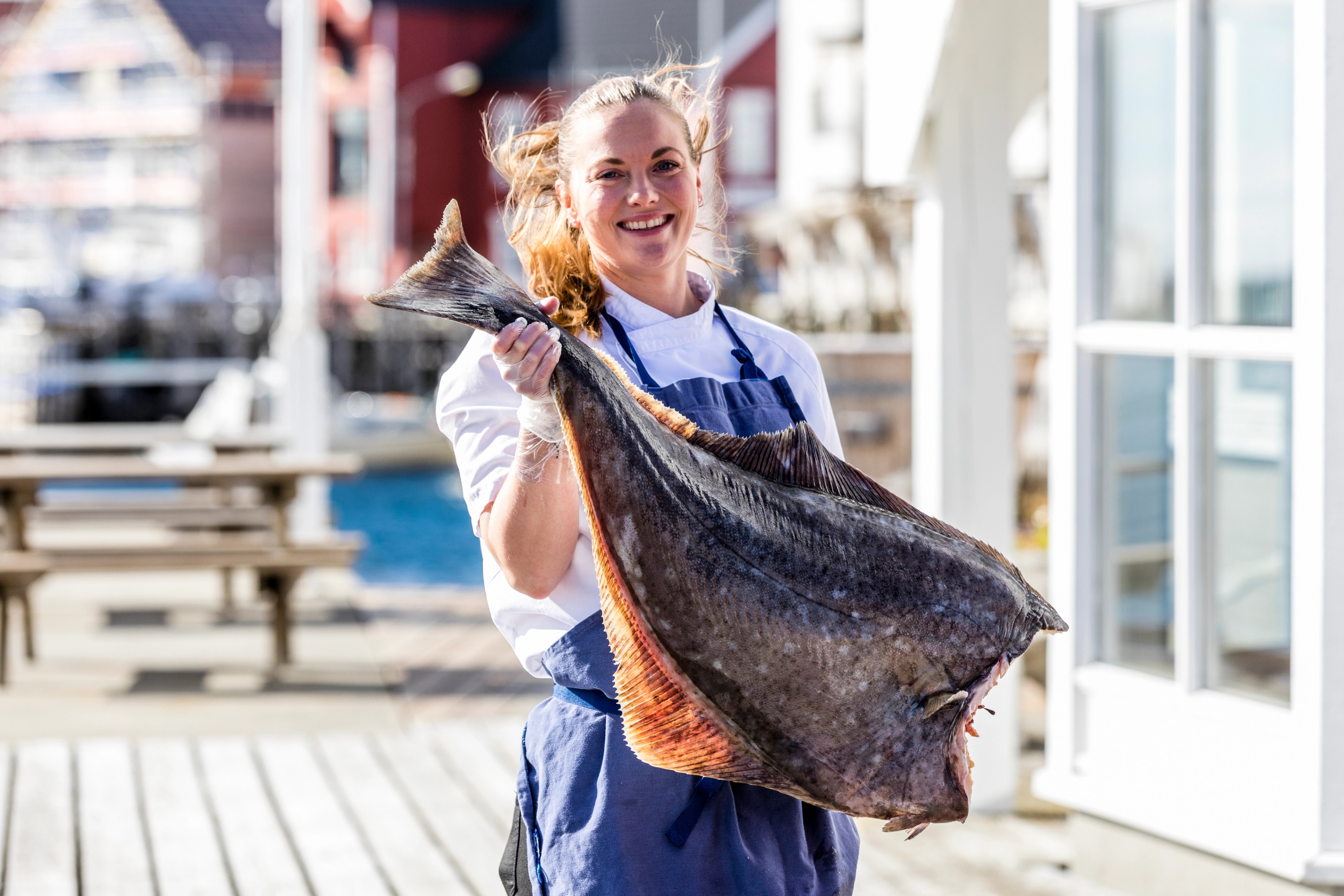 a woman with a big halibut at Henningsvær Bryggehotell