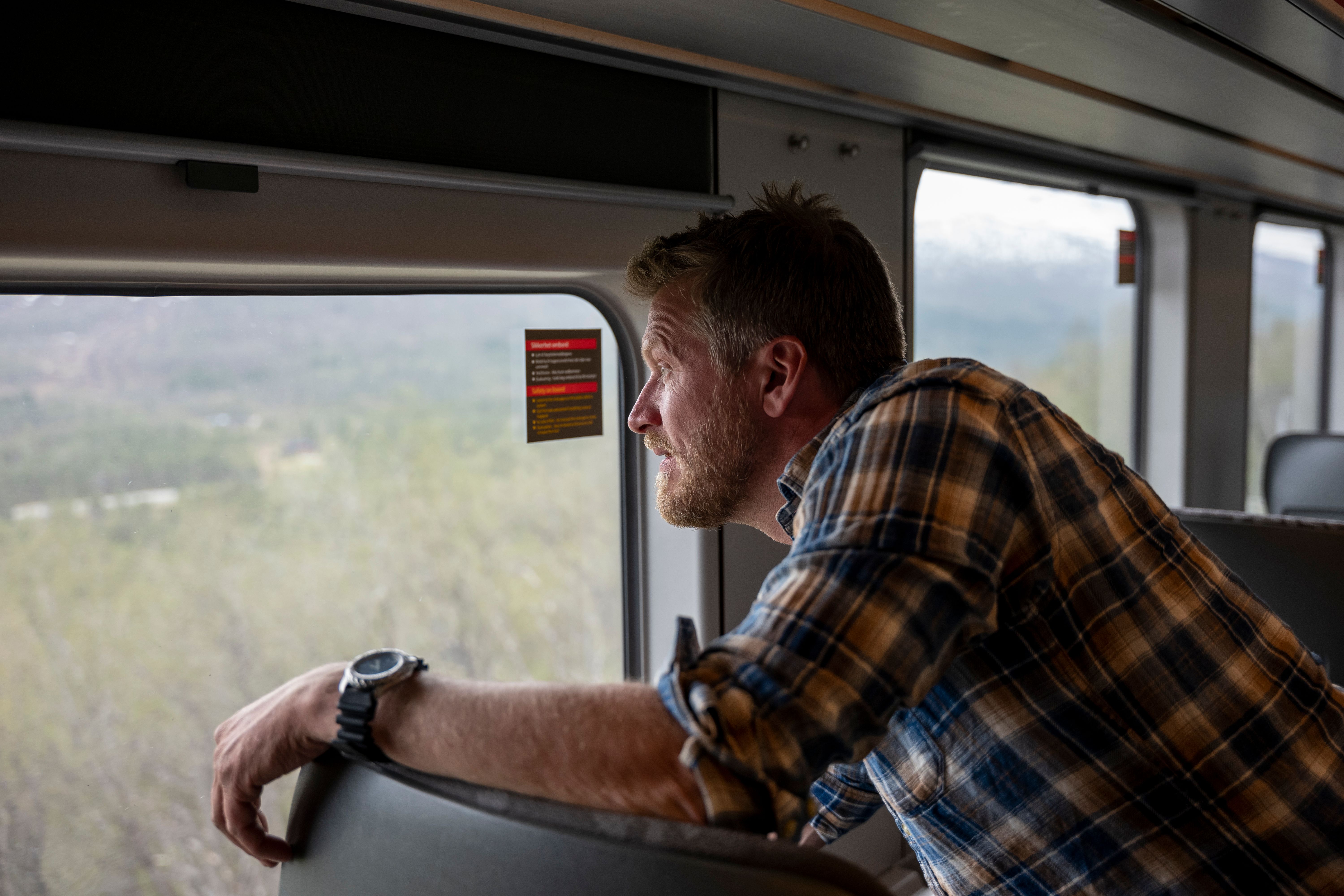 A man looks out the window on the Nordland Railway train, Norway.