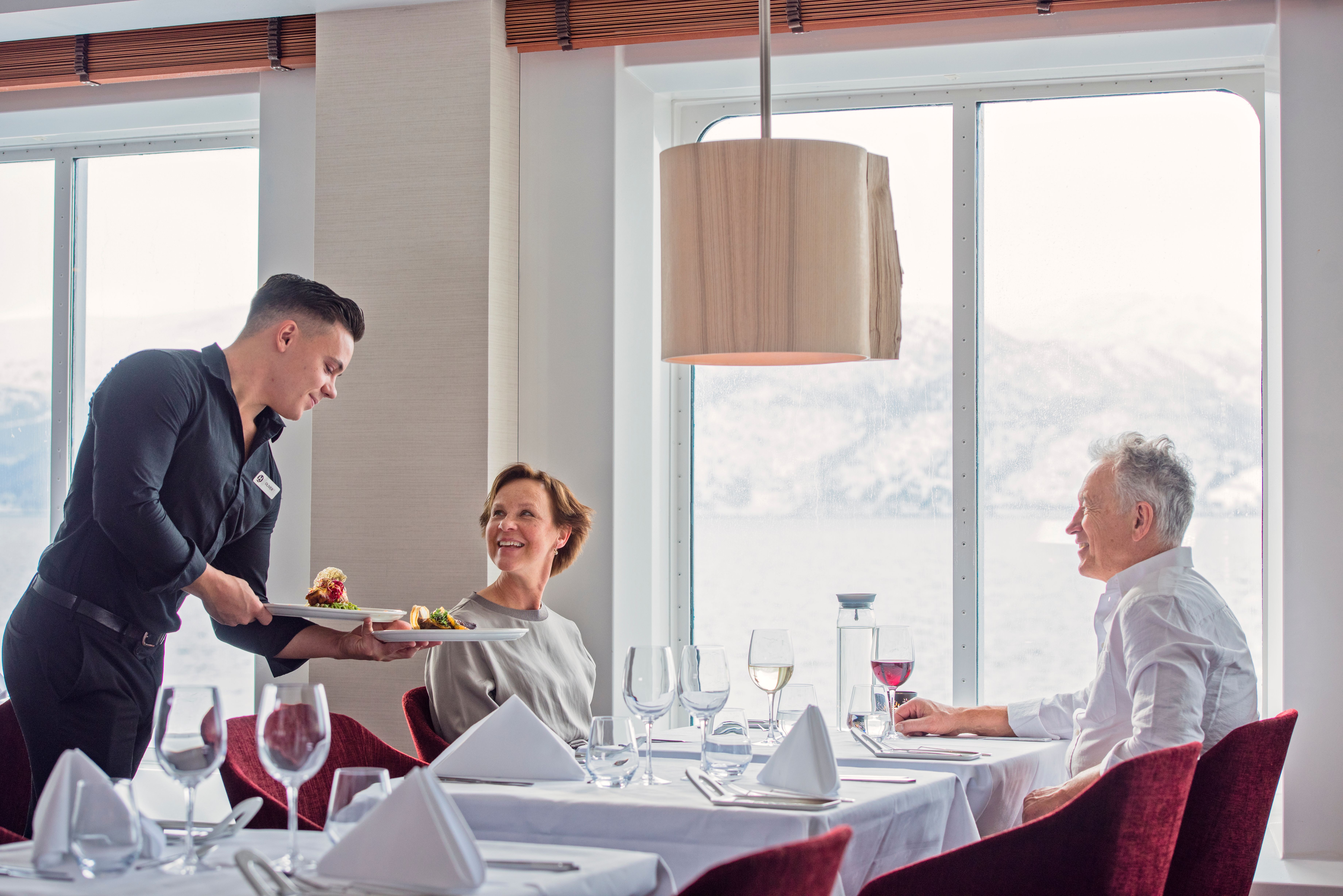 A couple travelling with Hurtigruten, eating good food.