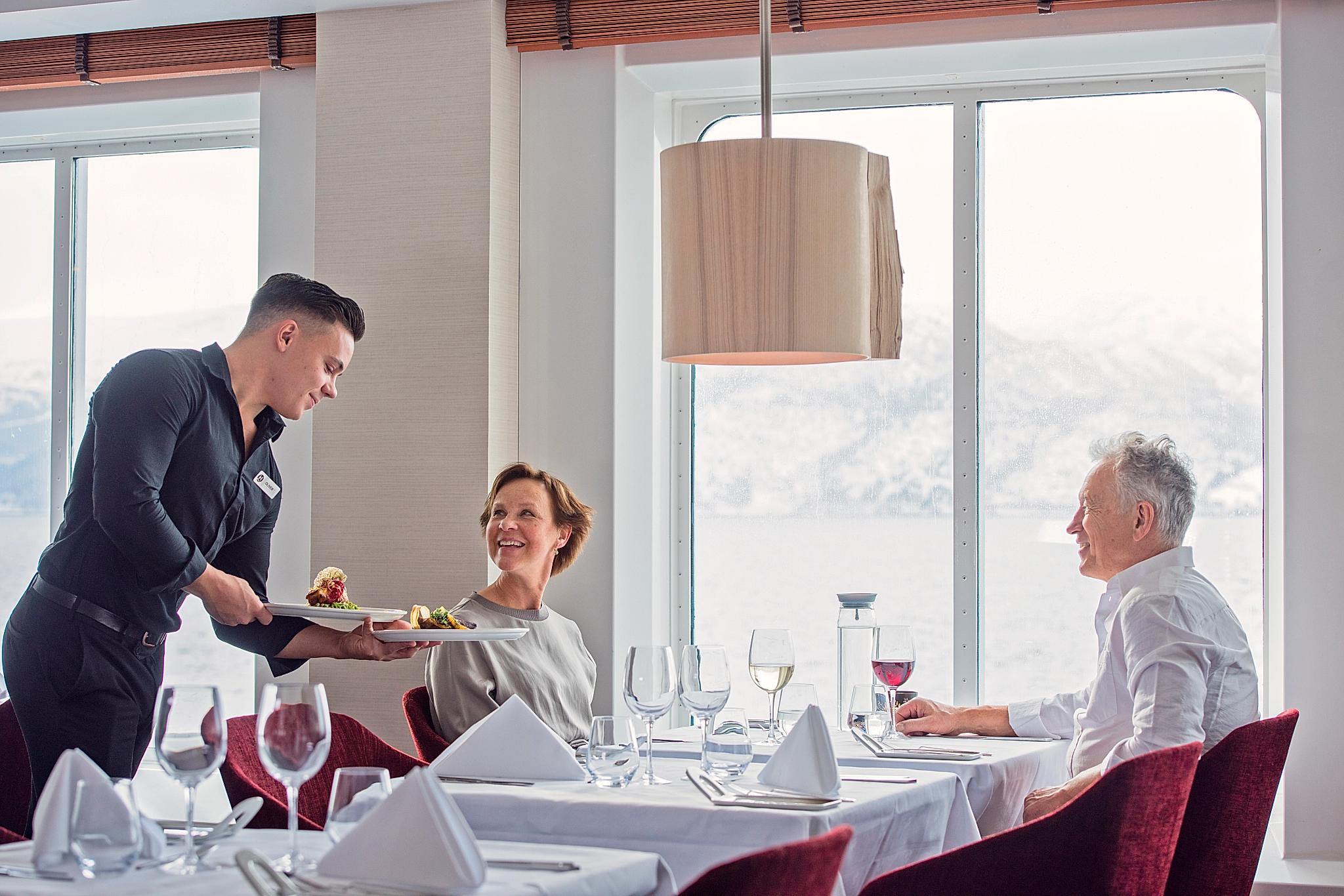 A couple travelling with Hurtigruten, eating good food.
