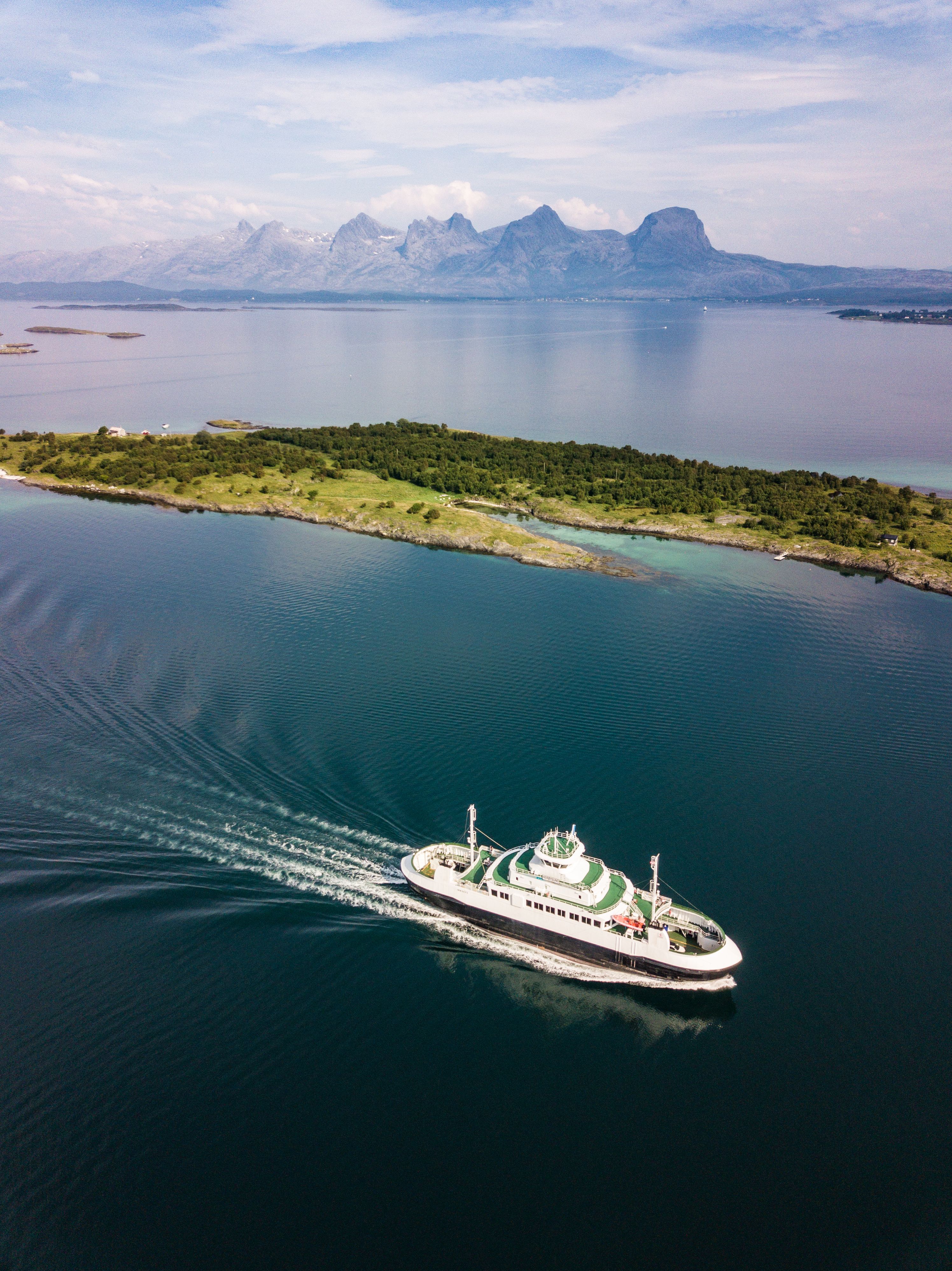 A ferry in travelling along the Helgeland coast in Northern Norway. In the background: the mountain range The seven sisters.