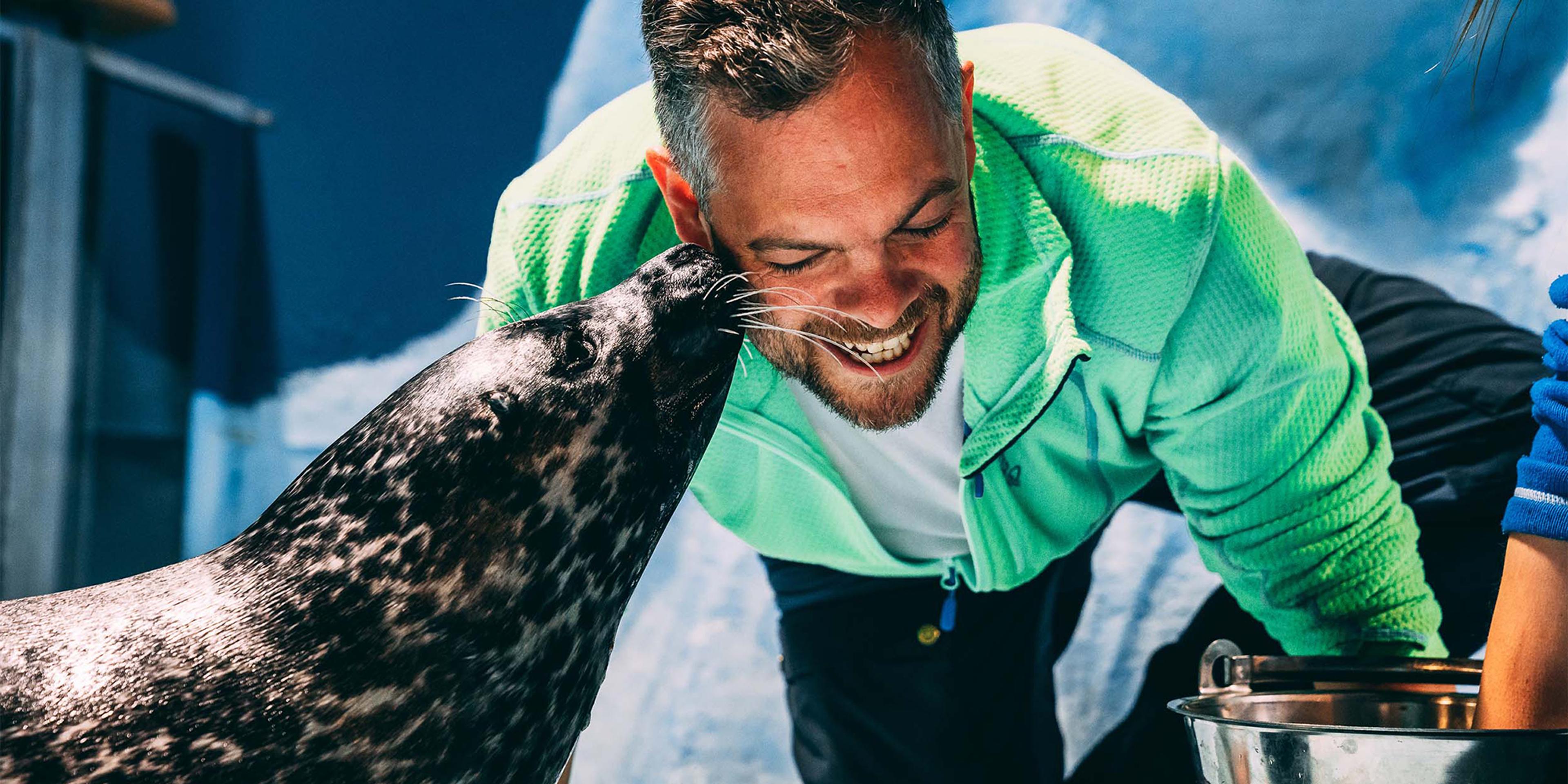 A seal is kissing his caretaker on the cheek at Polaria, the world's northernmost aquarium, in Tromsø, Northern Norway.