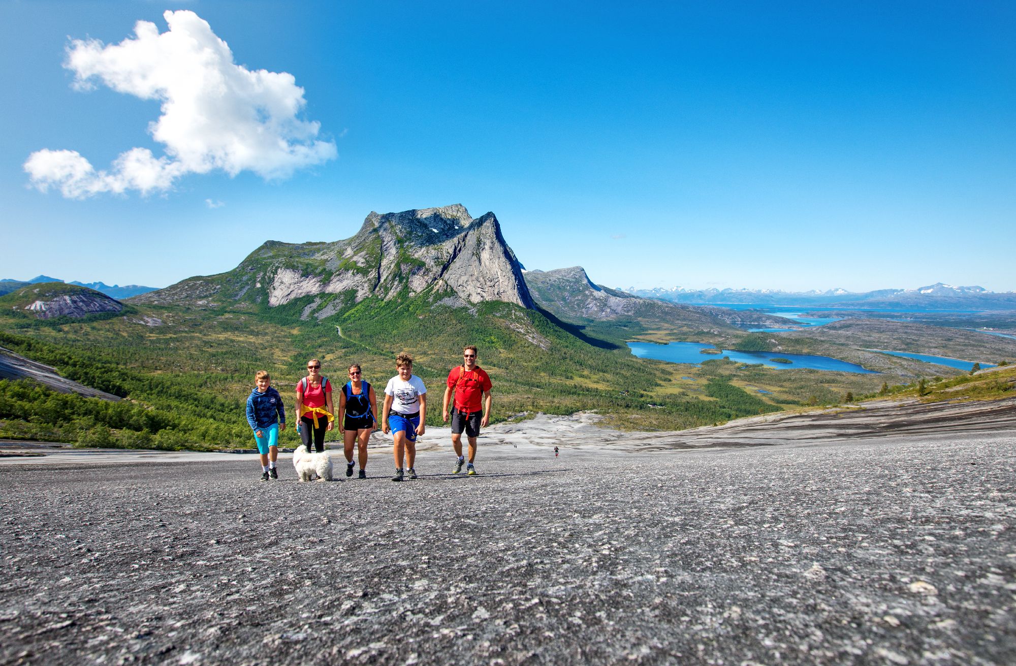 A family is hiking the Verdenssvaet hill by Efjorden in Narvik, Northern Norway