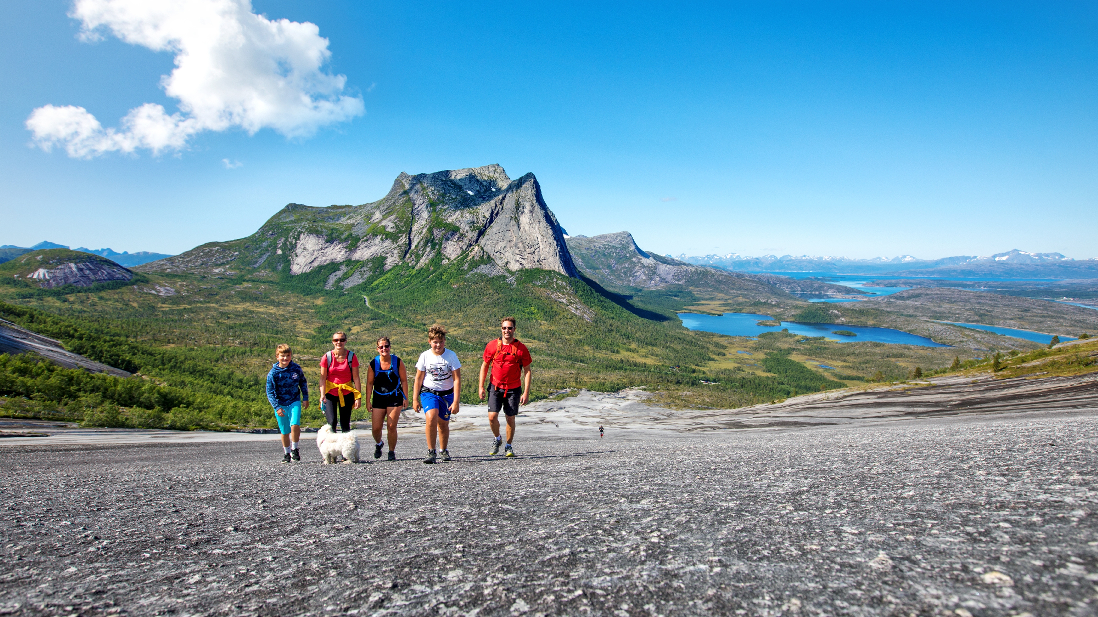 A family is hiking the Verdenssvaet hill by Efjorden in Narvik, Northern Norway