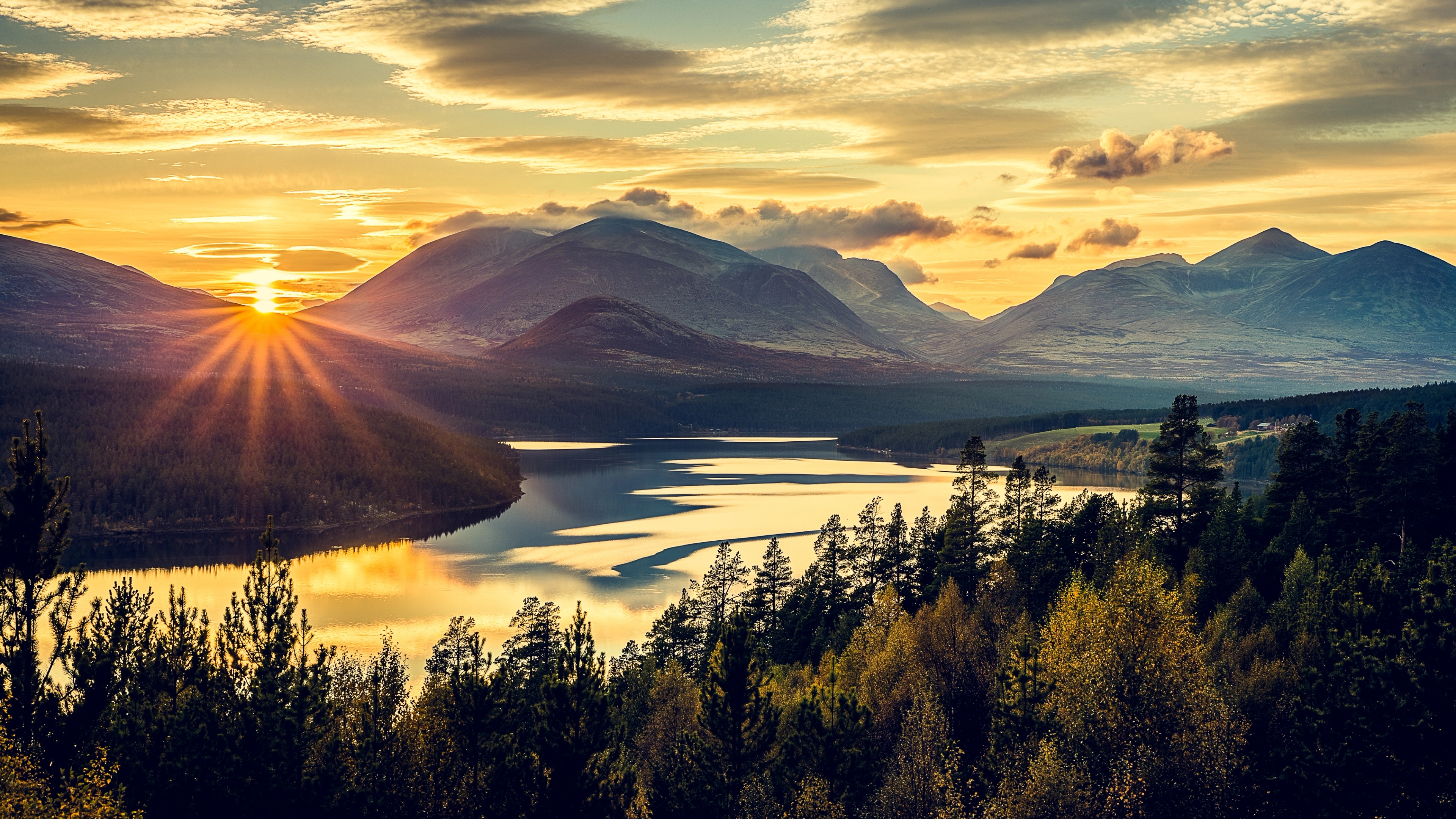 Overview of the mountains, trees and the fjord in Rondane national park, Eastern Norway, at sunset.