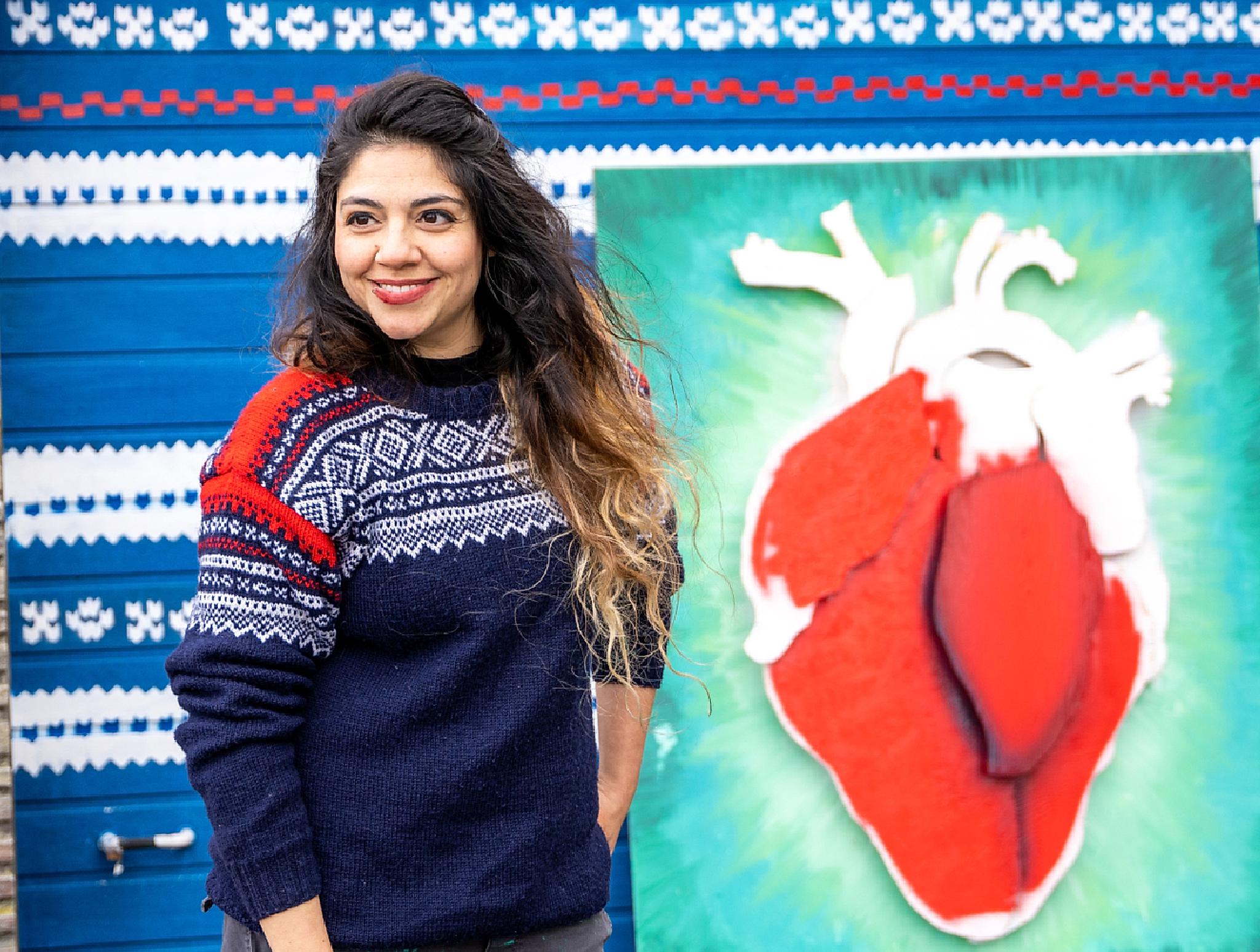 Street artist Algebra standing in front of a piece in progress, wearing the Marius sweater, Stavanger, Fjord Norway.