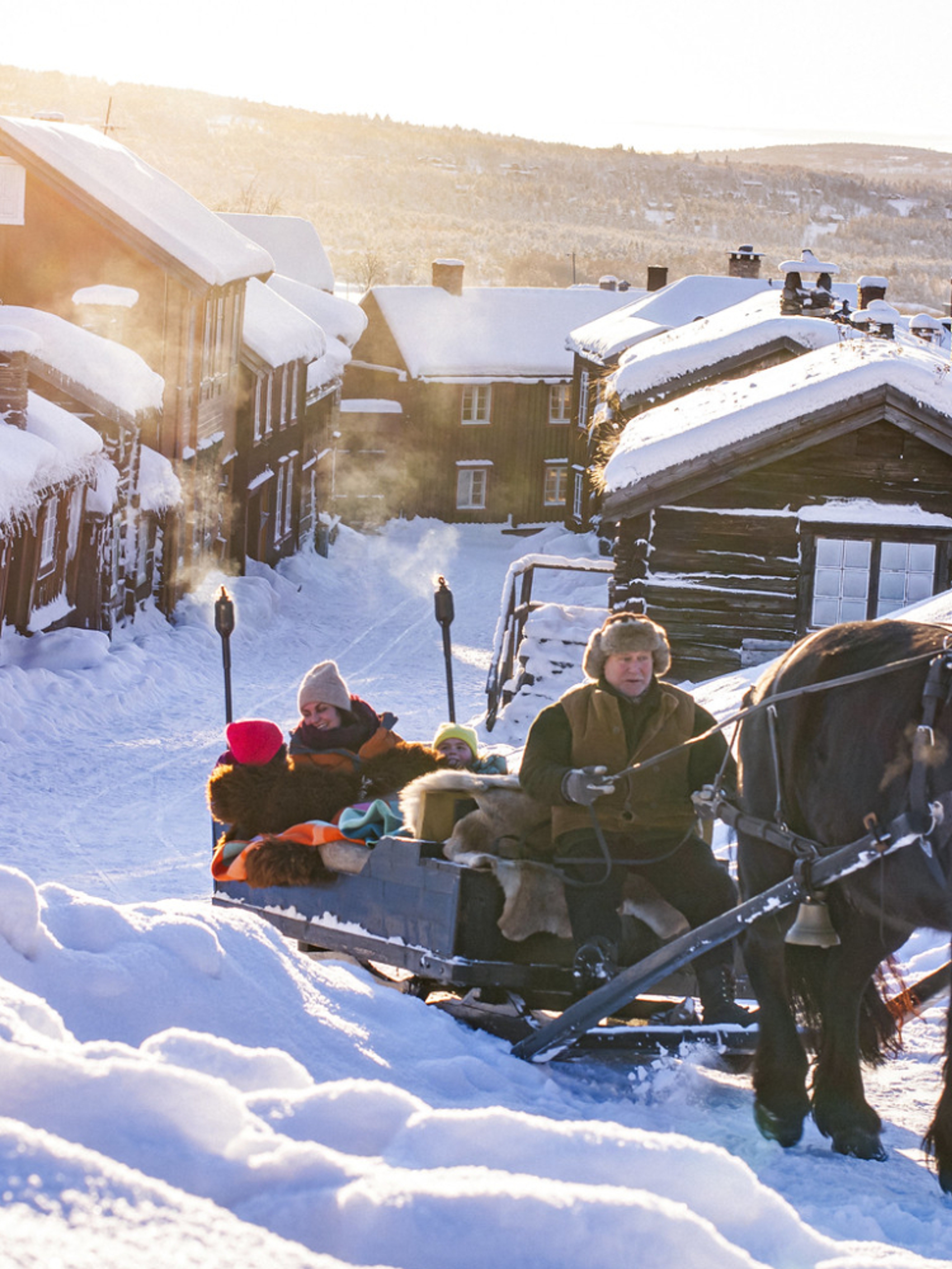 Three people riding a horse and sleigh at Røros a cold winter day