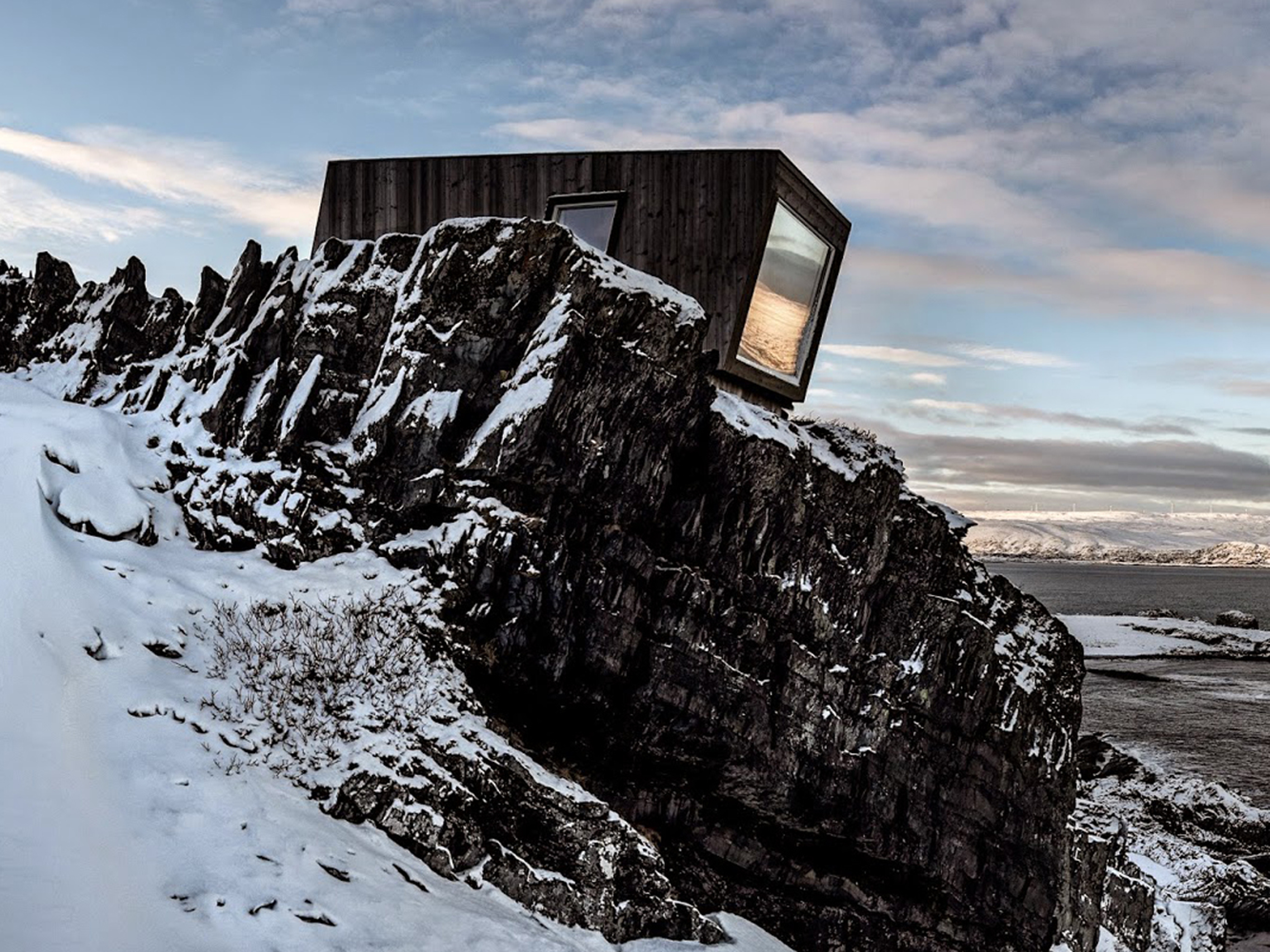 A birdwatching shelter in the snowy landscape of Kongsfjord, Northern Norway