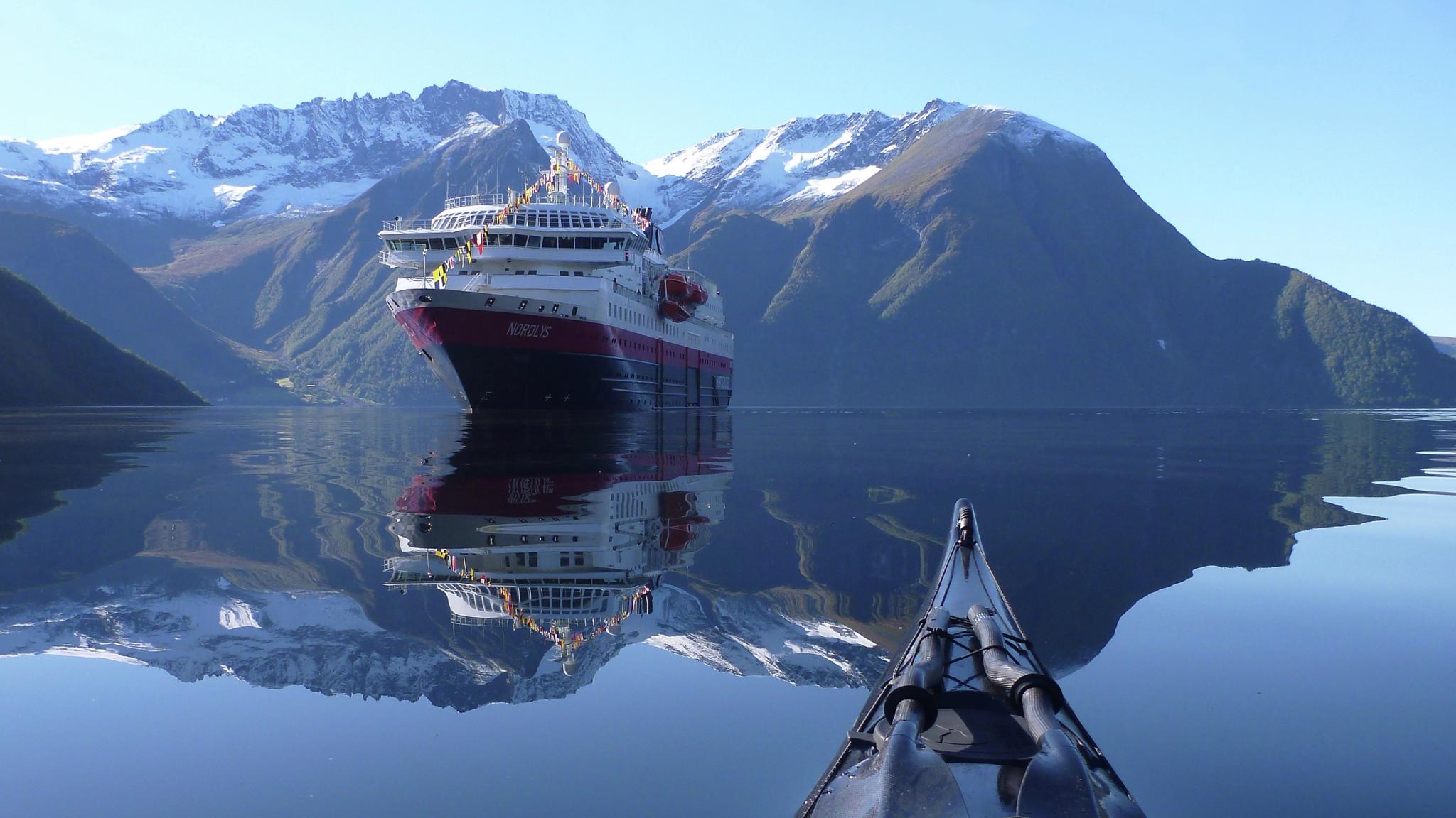 Aussicht auf das Hurtigruten-Schiff MS Nordlys von einem Kaja auf dem Hjørundfjord