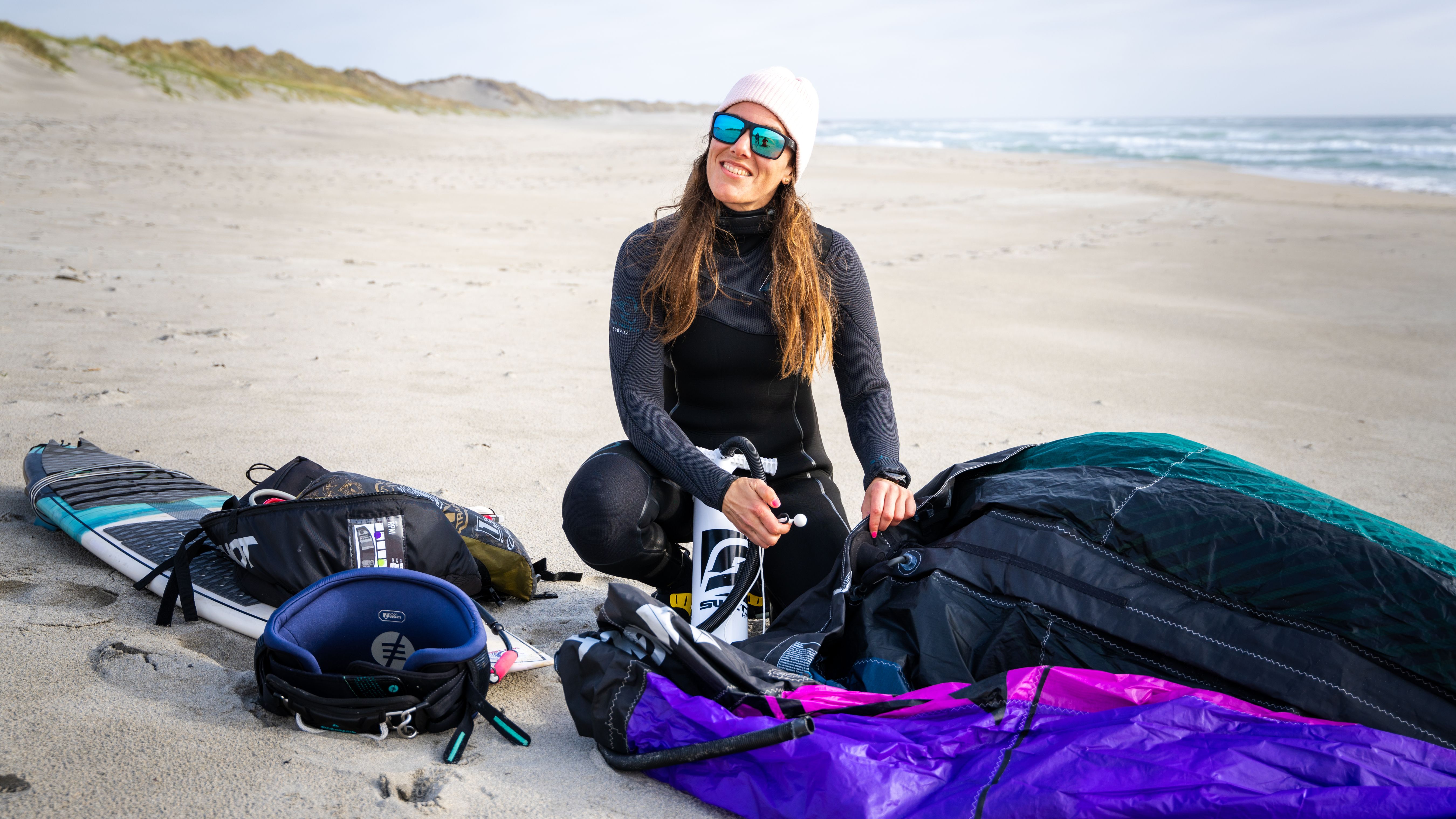 A woman at a beach with kiting equipment outside of Stavanger, Fjord Norway.