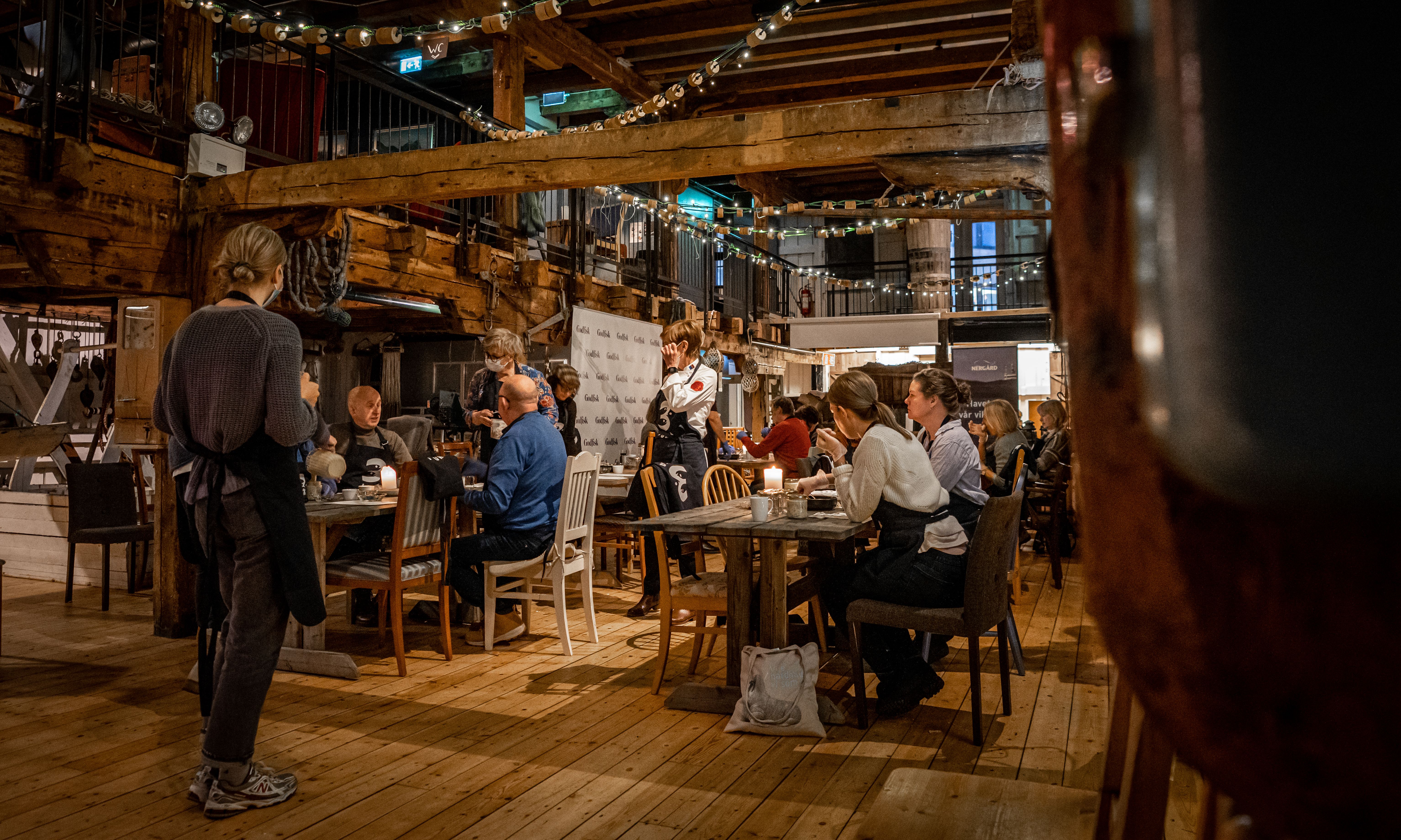 People eating and drinking at a fisherman's cabin in Tromsø