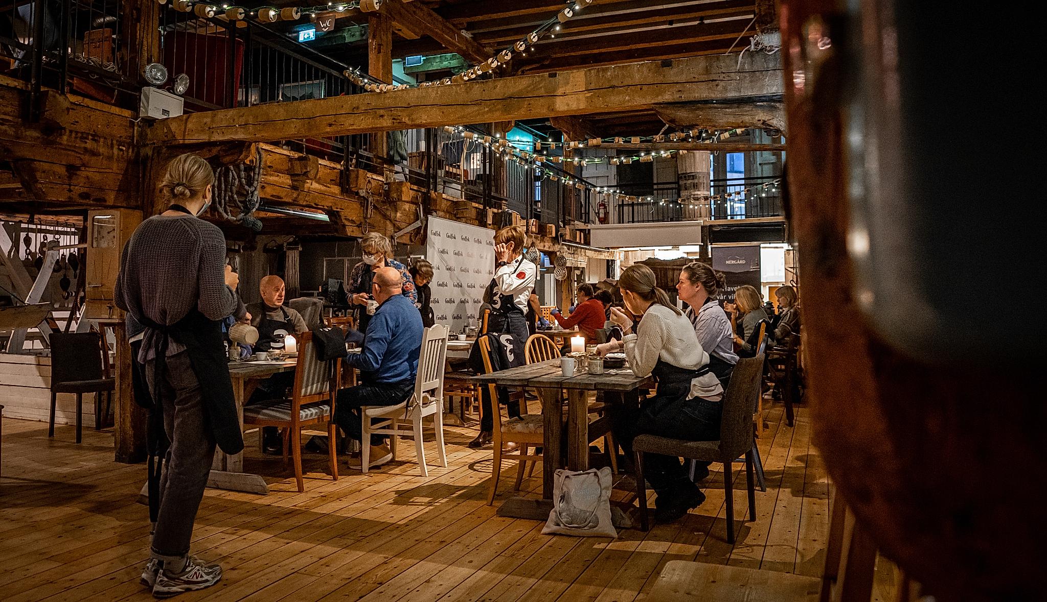 People eating and drinking at a fisherman's cabin in Tromsø
