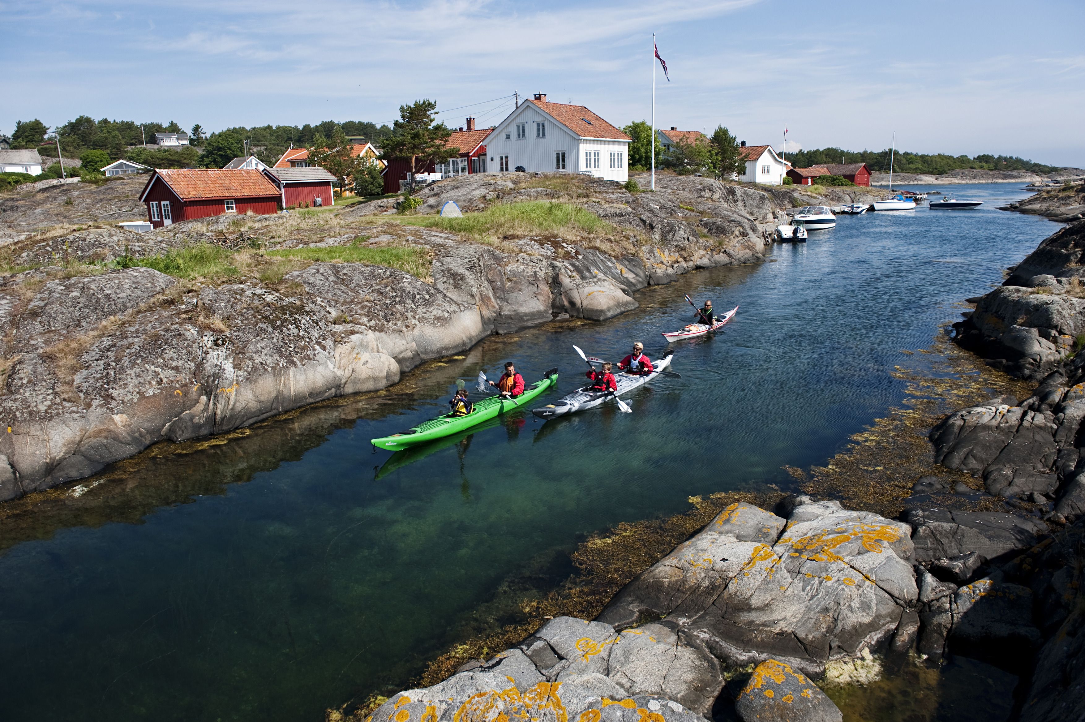 A family kayaking through a strait in the archipelago of Risør, Southern Norway