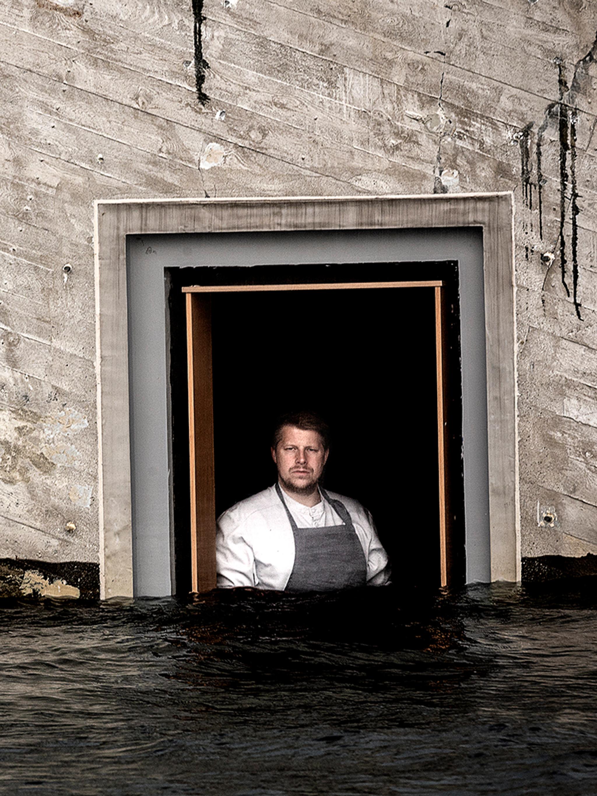 Chef Nicolai Ellitsgaard is looking out of the window at the partially submerged restaurant Under in Lindesnes, Southern Norway