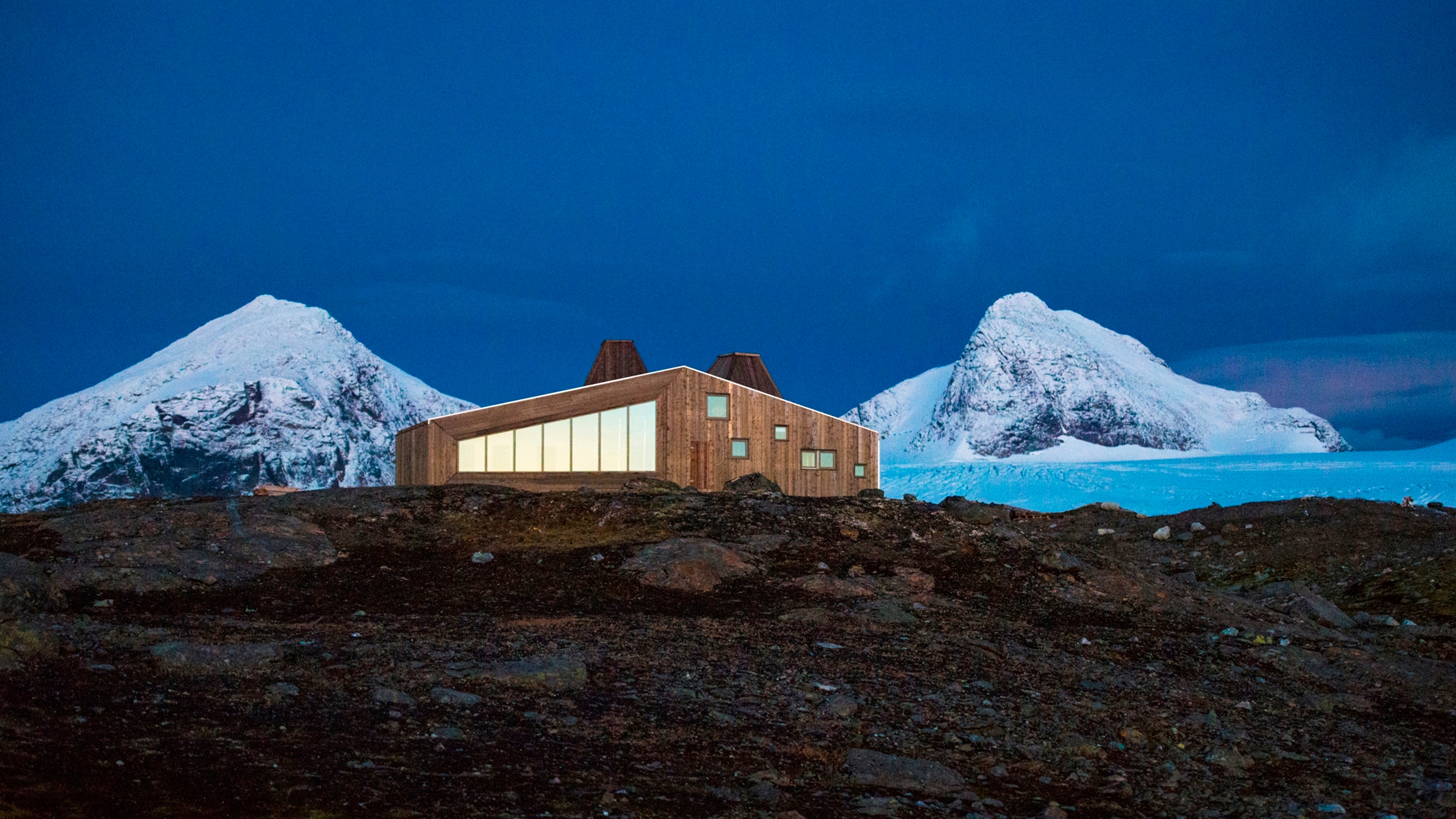 Rabothytta på Helgeland i Nord-Norge med snødekte fjell i bakgrunnen