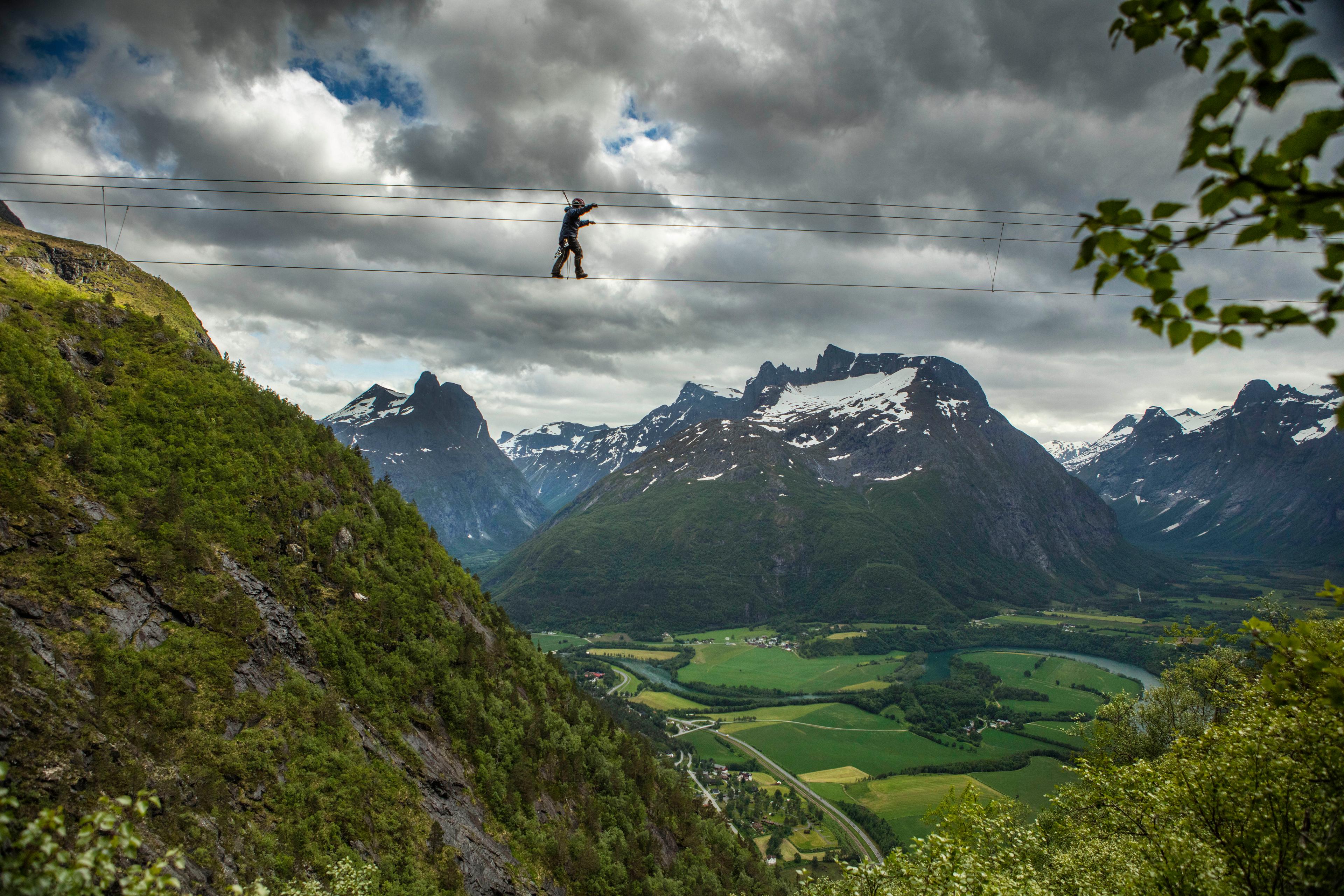 A person crossing the Romsdalsstigen via ferrata in Åndalsnes in Northwest, Fjord Norway