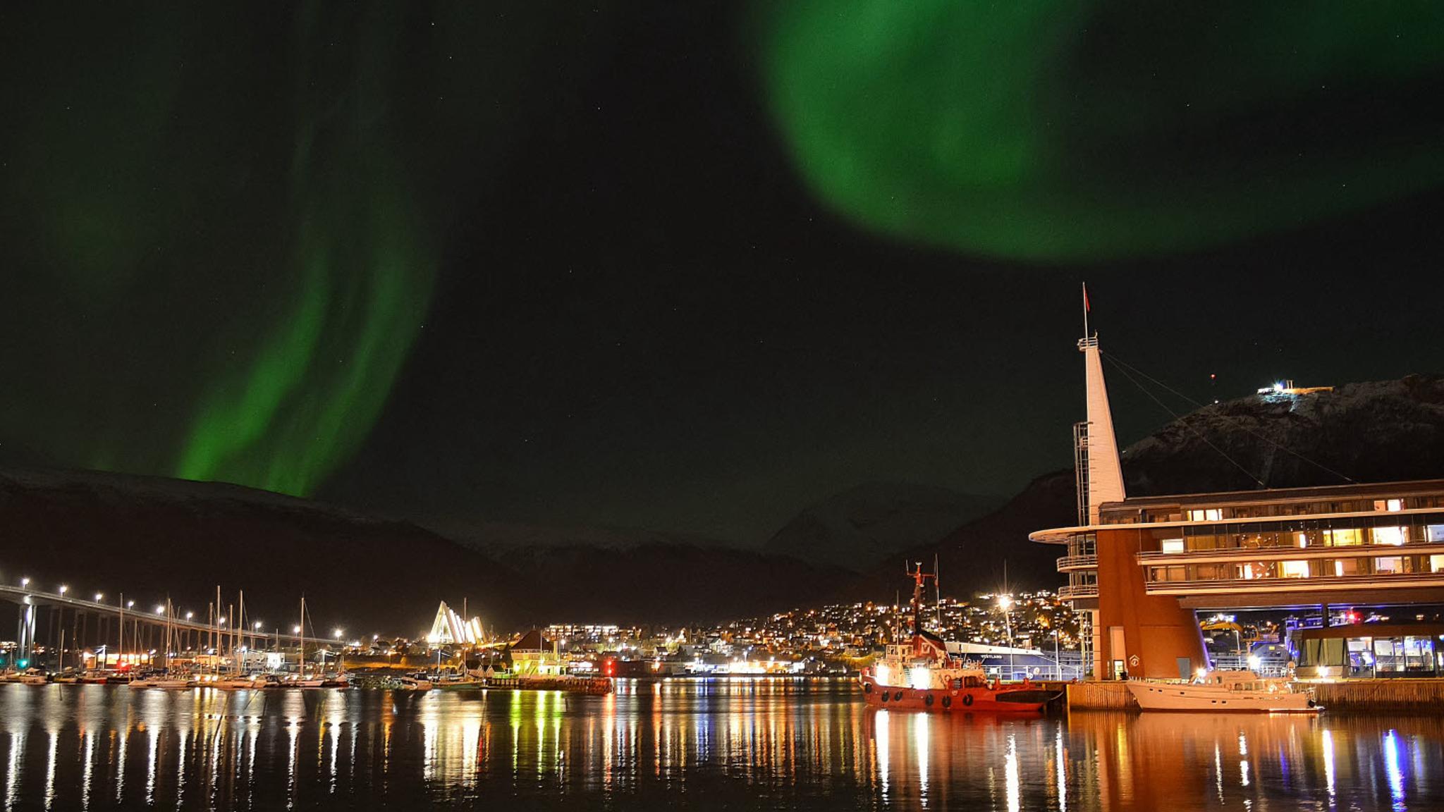 A city view of Tromsø and Scandic Ishavshotel under the northern lights