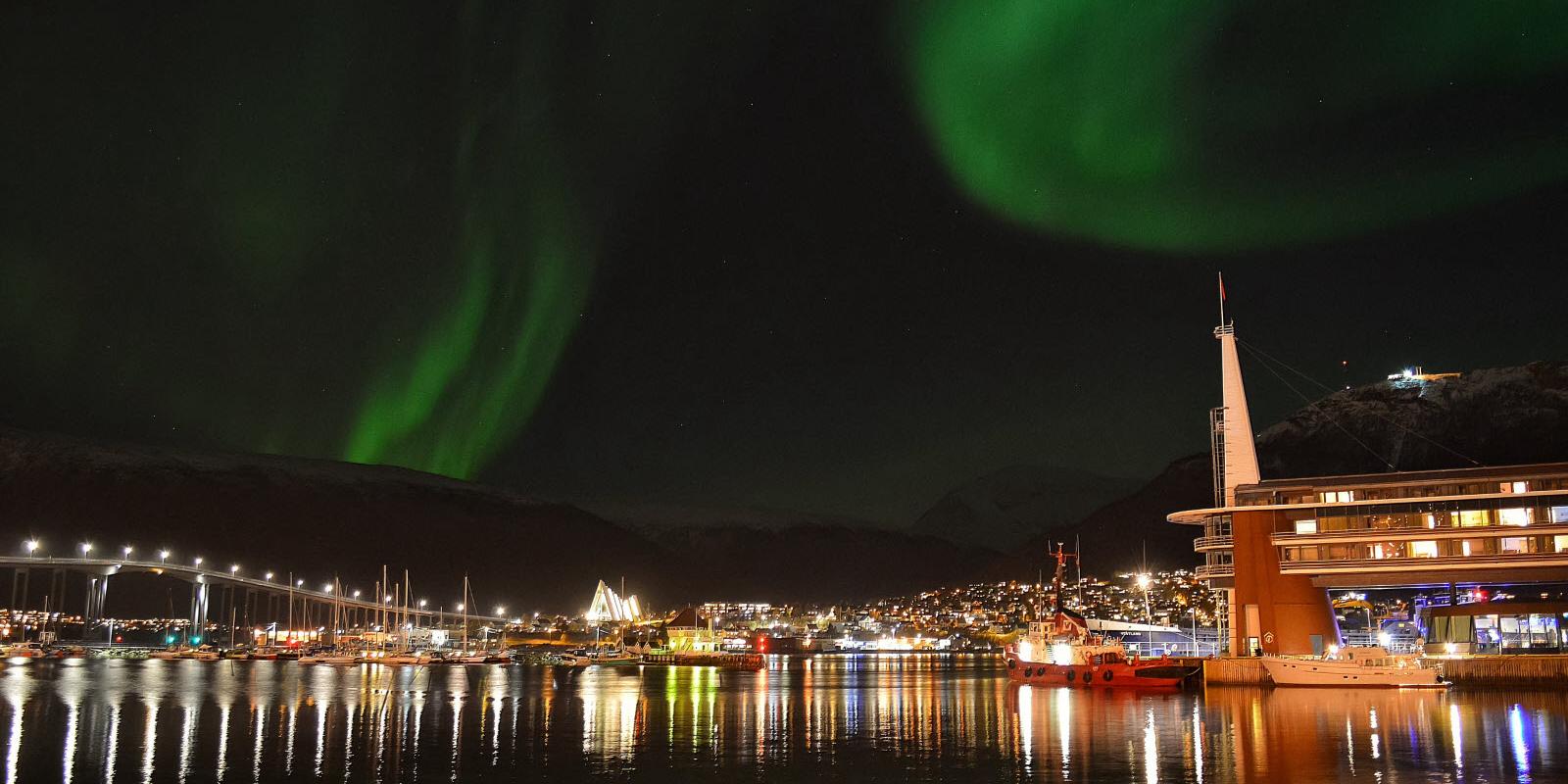 A city view of Tromsø and Scandic Ishavshotel under the northern lights