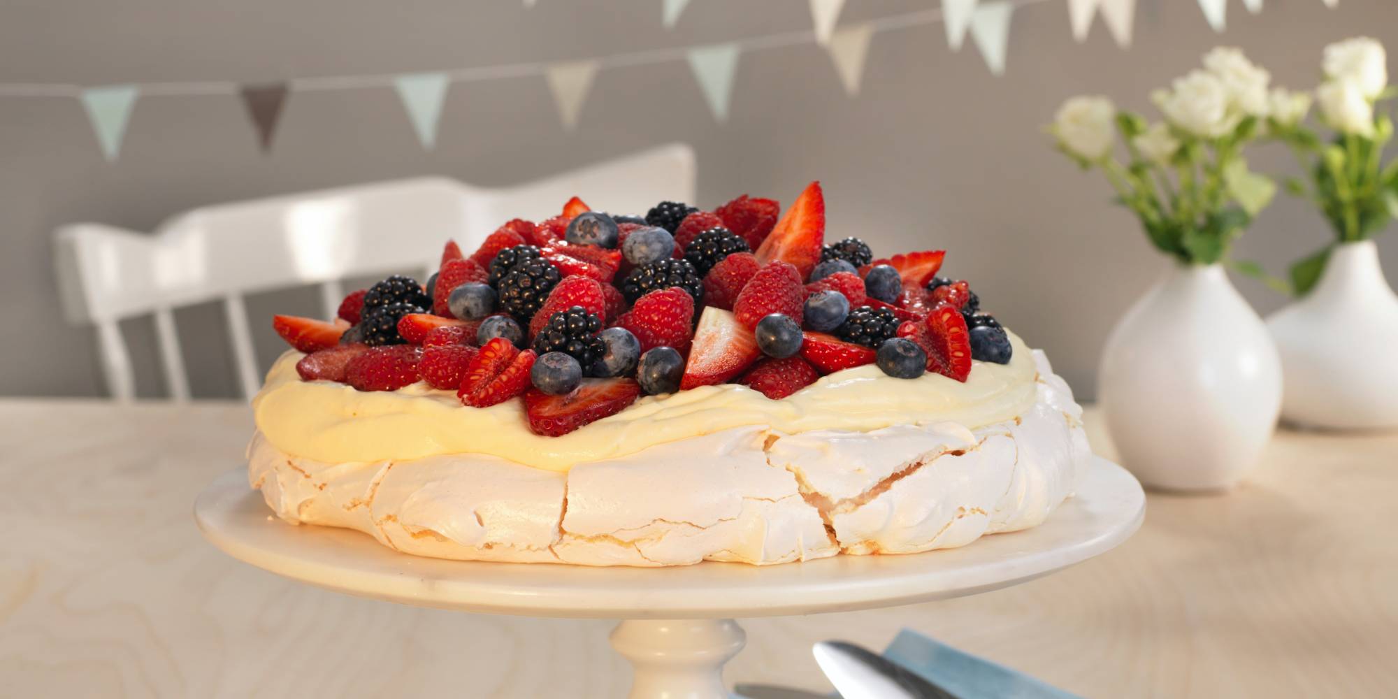 A pavlova decorated with fresh berries