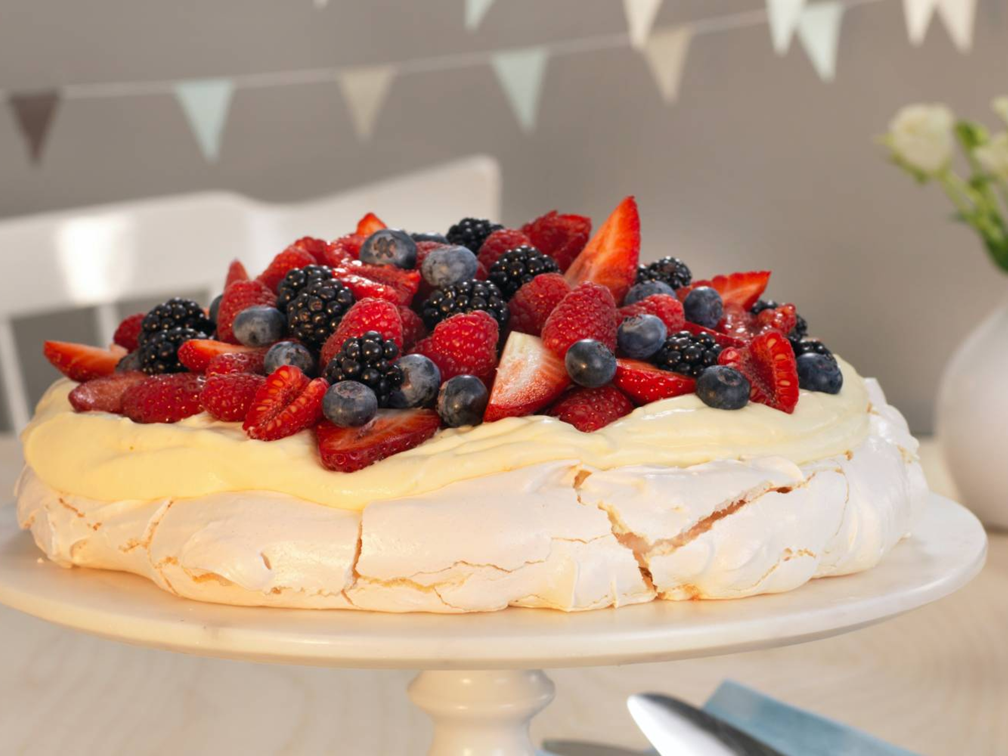 A pavlova decorated with fresh berries