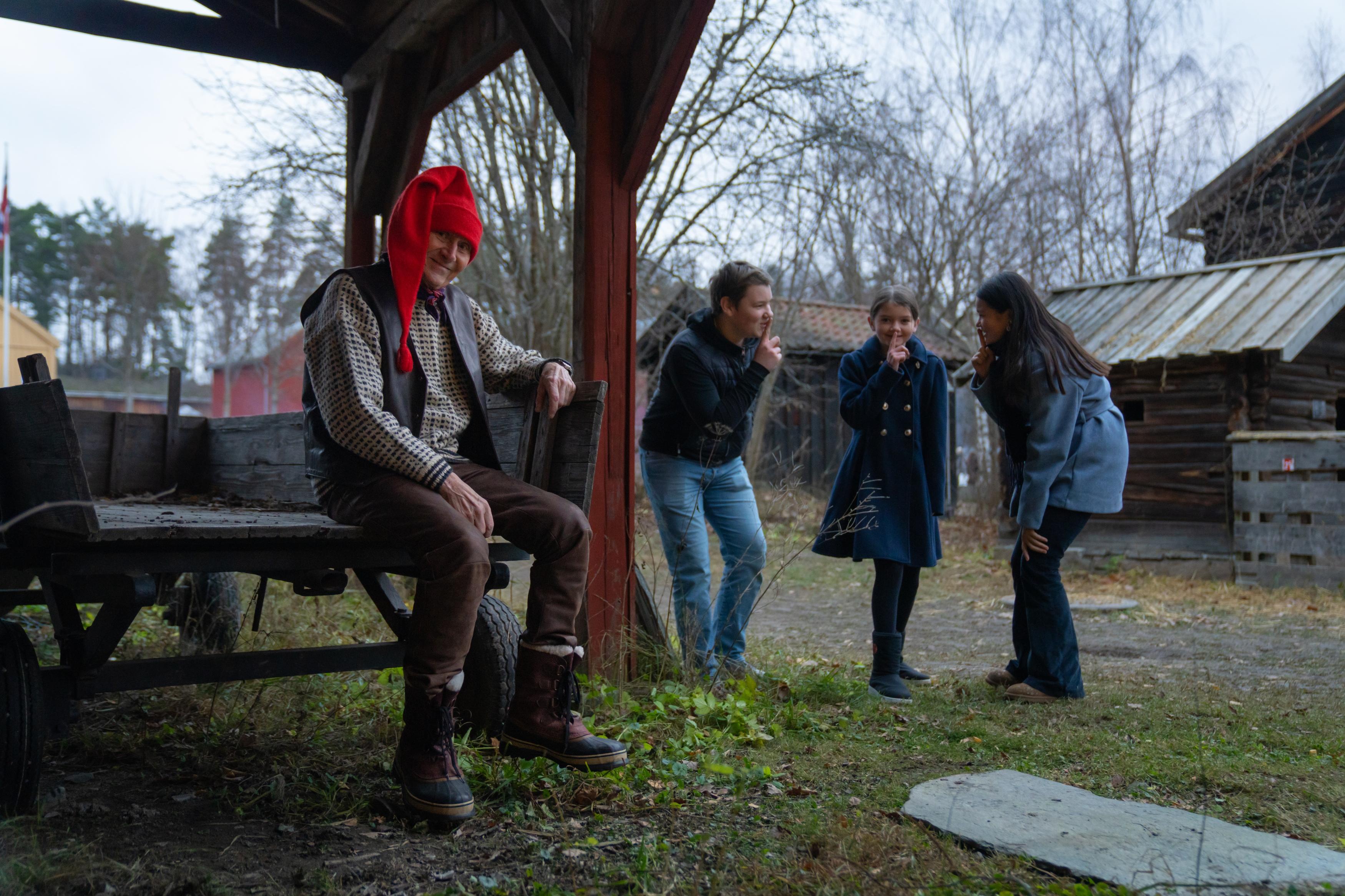 Three kids are lurking beheind the Norwegian Santa at the Christmas market in Norsk Folkemuseum in Bygdøy, Eastern Norway