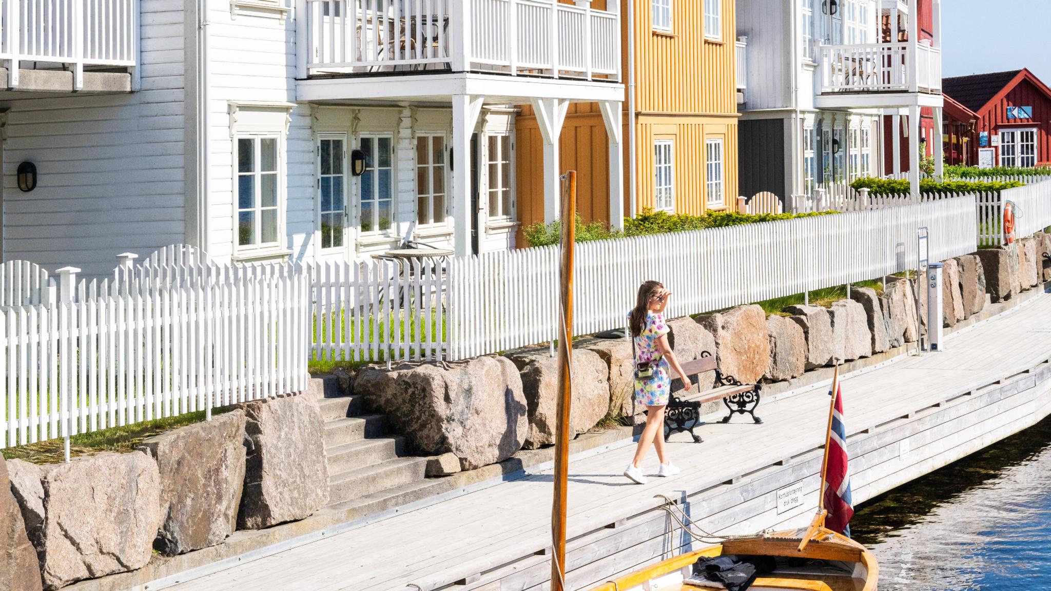 Girl walking along a harbor in Gjeving, Southern Norway