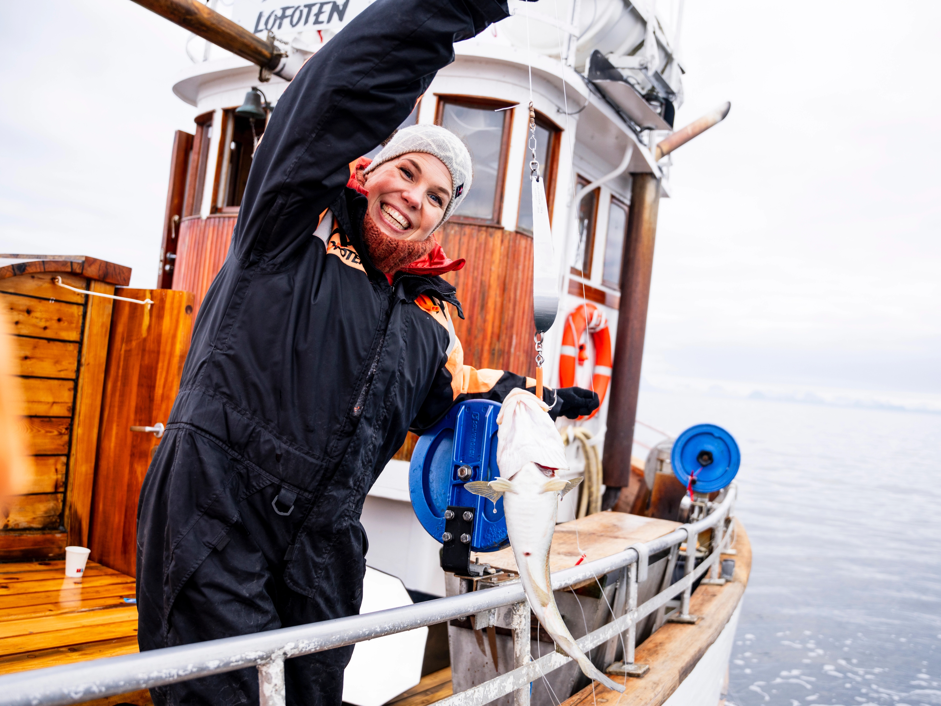 En kvinne drar opp en fisk