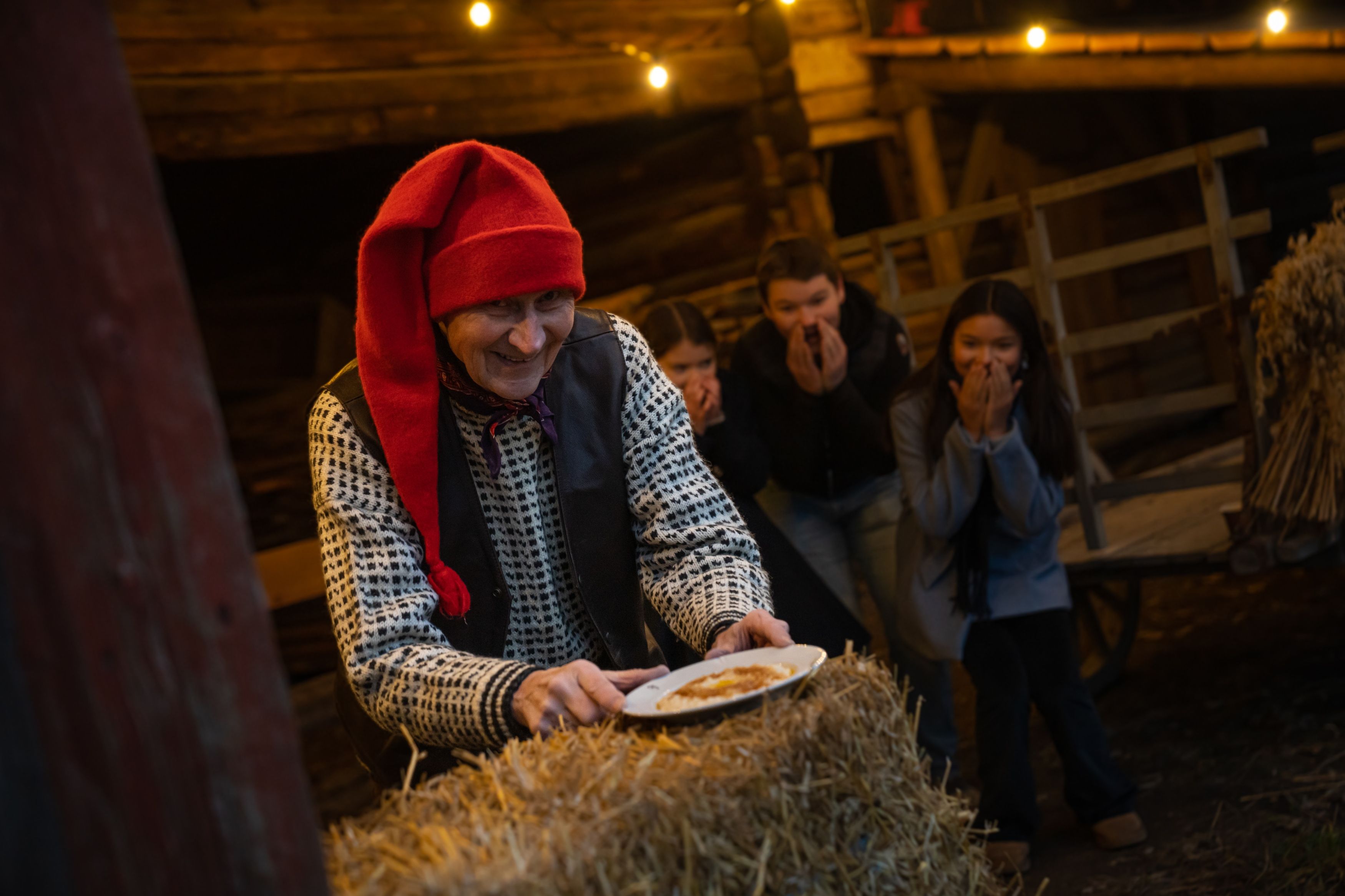 The Norwegian Santa is getting a hold of the porridge, while children is excited in the background at Bygdøy, Eastern Norway