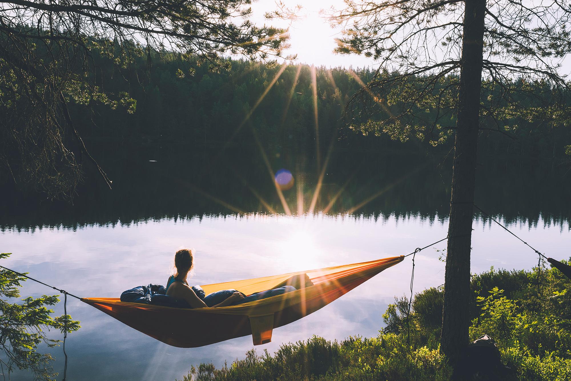 Woman in hammock at sunset in the Nordmarka forest in Oslo, Eastern Norway