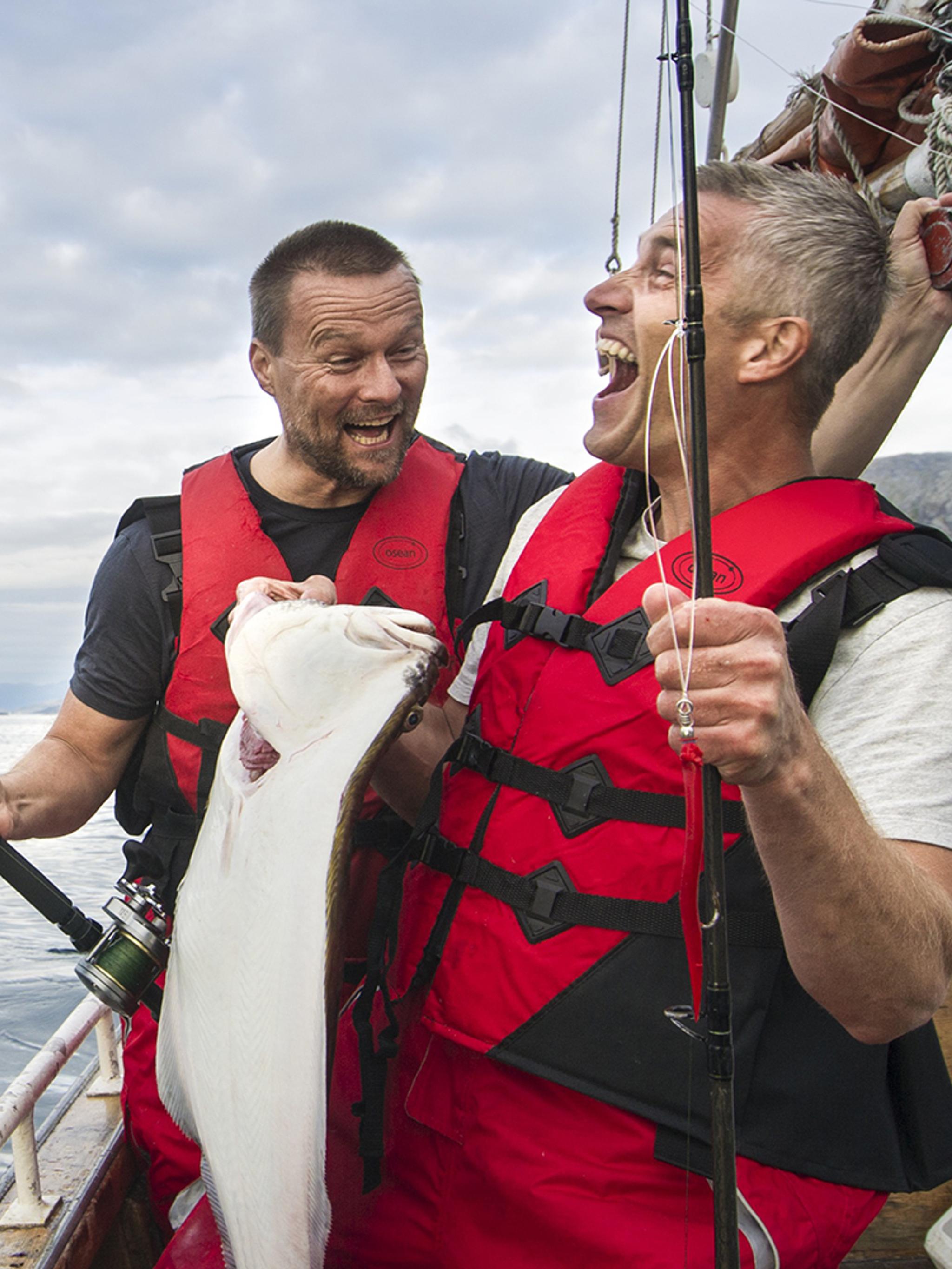 To menn fisker fra en båt i Tromsø