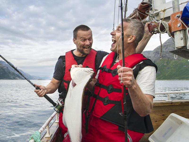 To menn fisker fra en båt i Tromsø