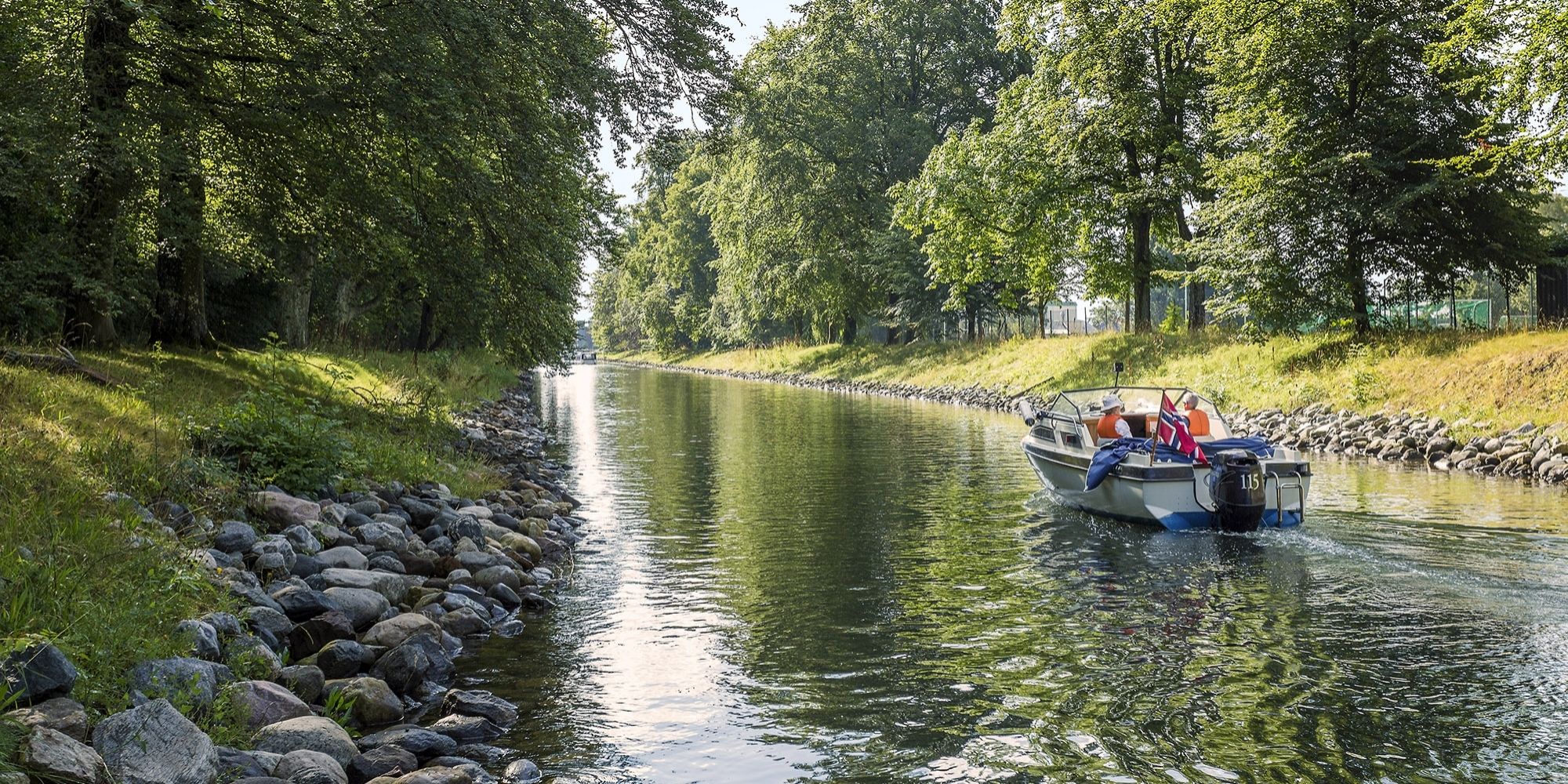 A boat drives in a leisurely pace in the Hortenkanalen canal in Horten in Vestfold, Eastern Norway