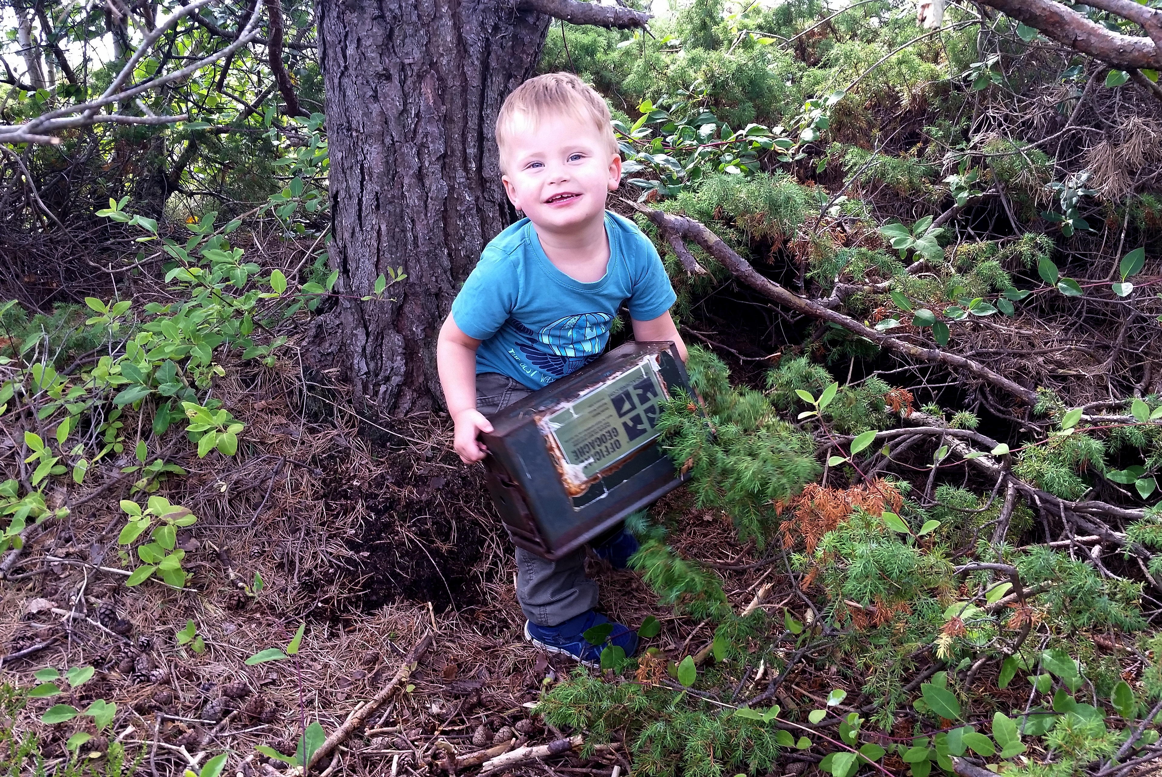 A boy geoaching next to a tree in Lyngor in Southern Norway