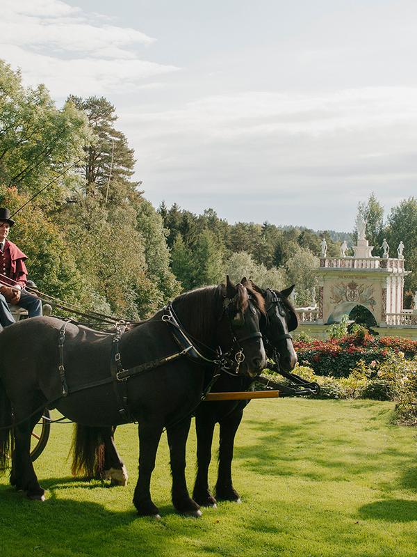 Mensen in een paardenkoets in het Havlystparken-park in de cultuurbestemming Ramme Gård in Hvitsten aan het Oslofjord in Oost-Noorwegen