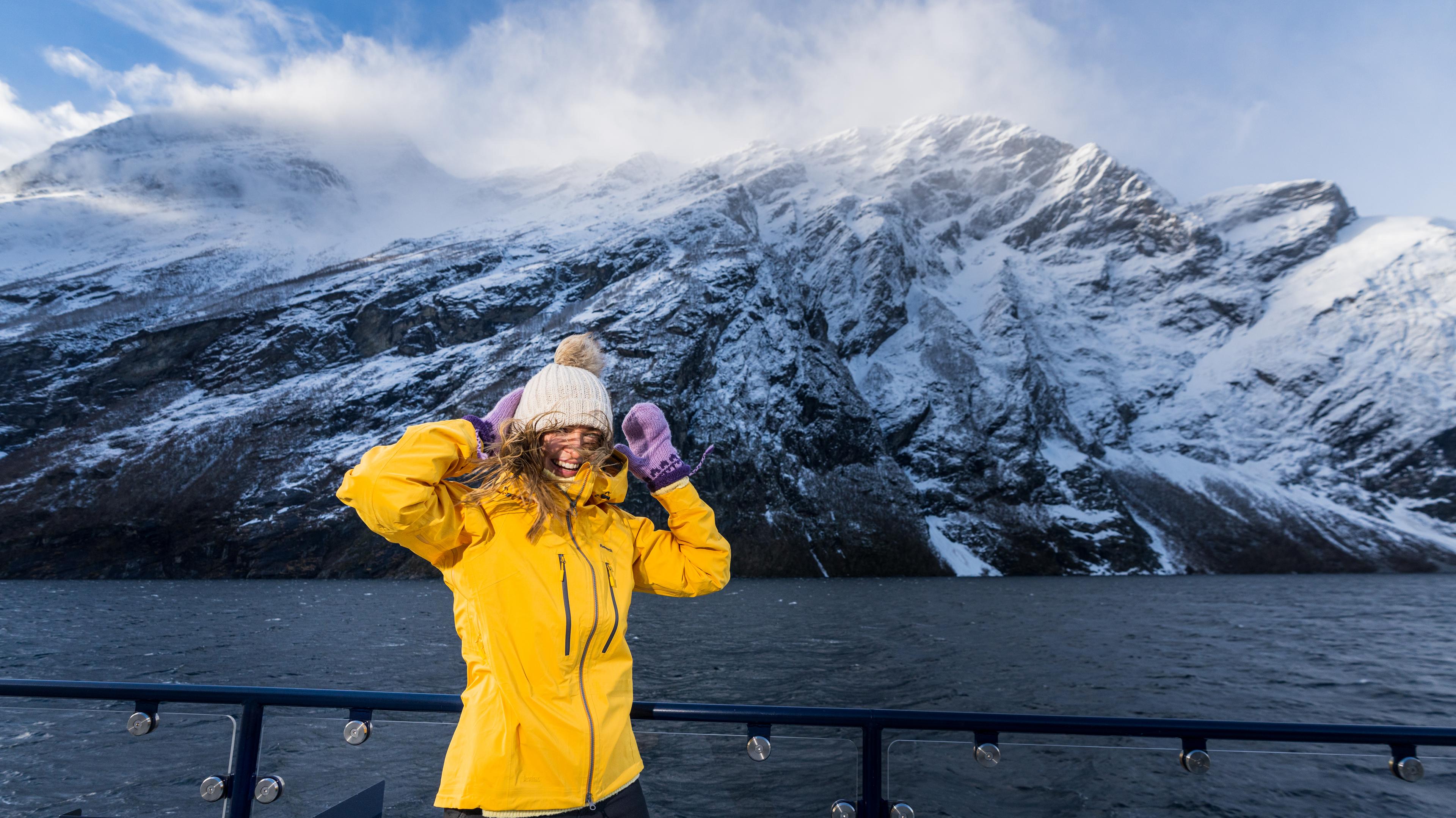 Women in windy conditions on deck at the Fjordrangers cruise boat in Geiranger, in winter