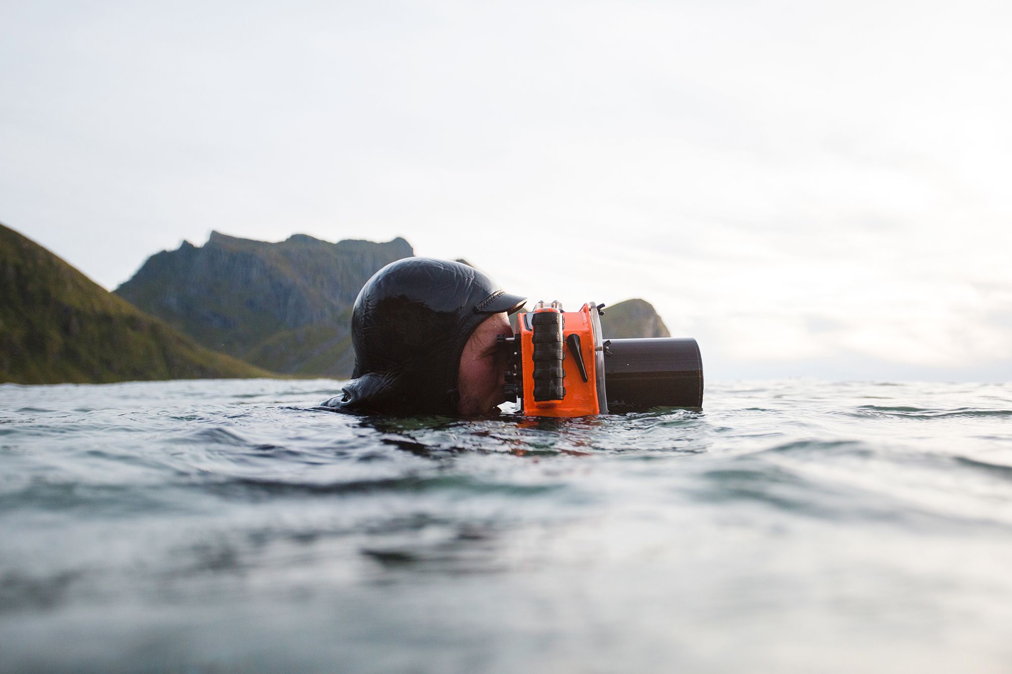 Hallvard Kolltveit, a surfer, swimming in the sea with a waterproof camera in Norway