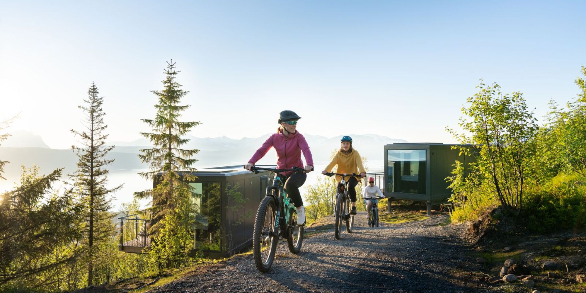 Three people summer biking at the Narvikfjellet with midnight sun