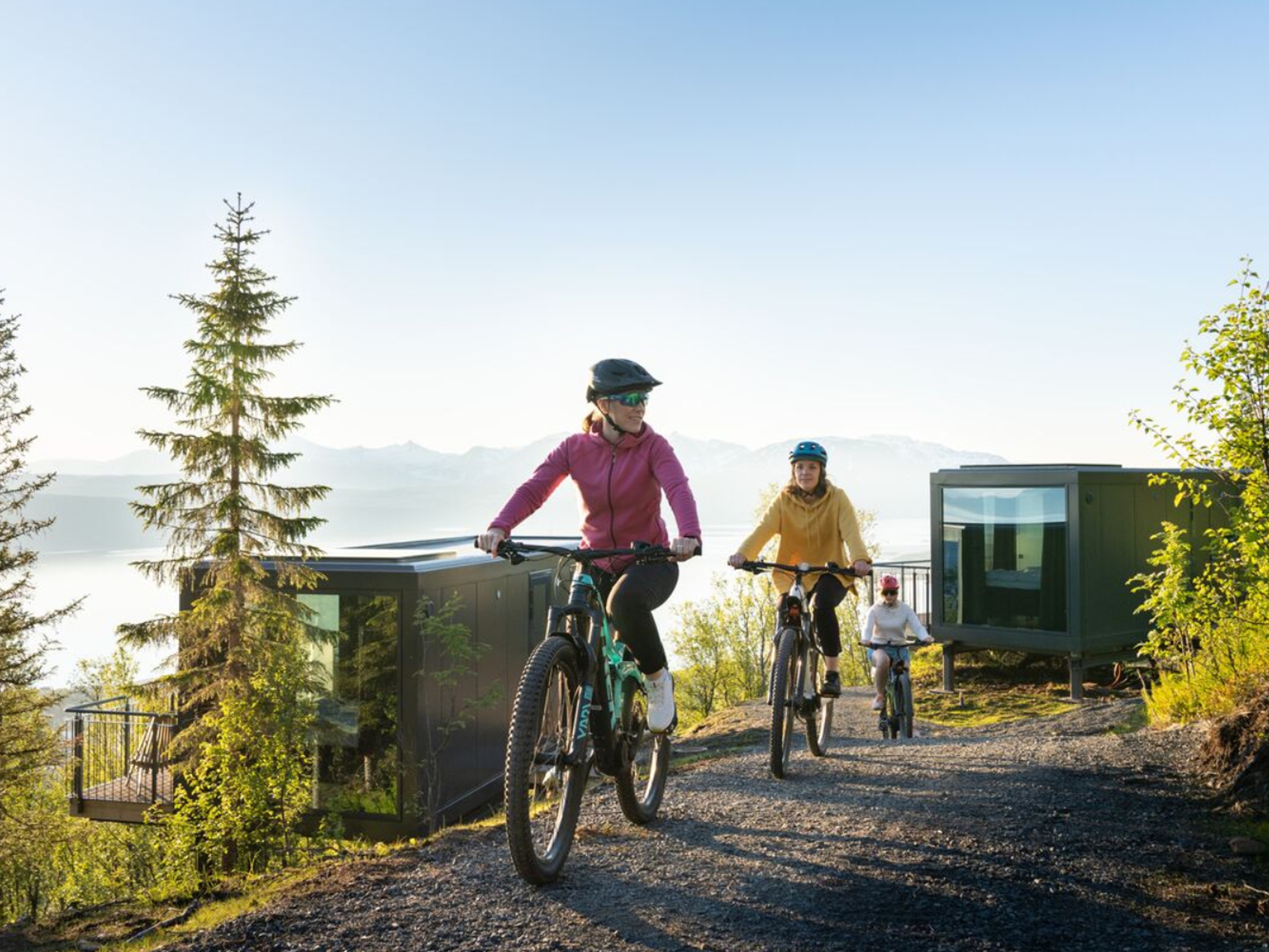 Three people summer biking at the Narvikfjellet with midnight sun