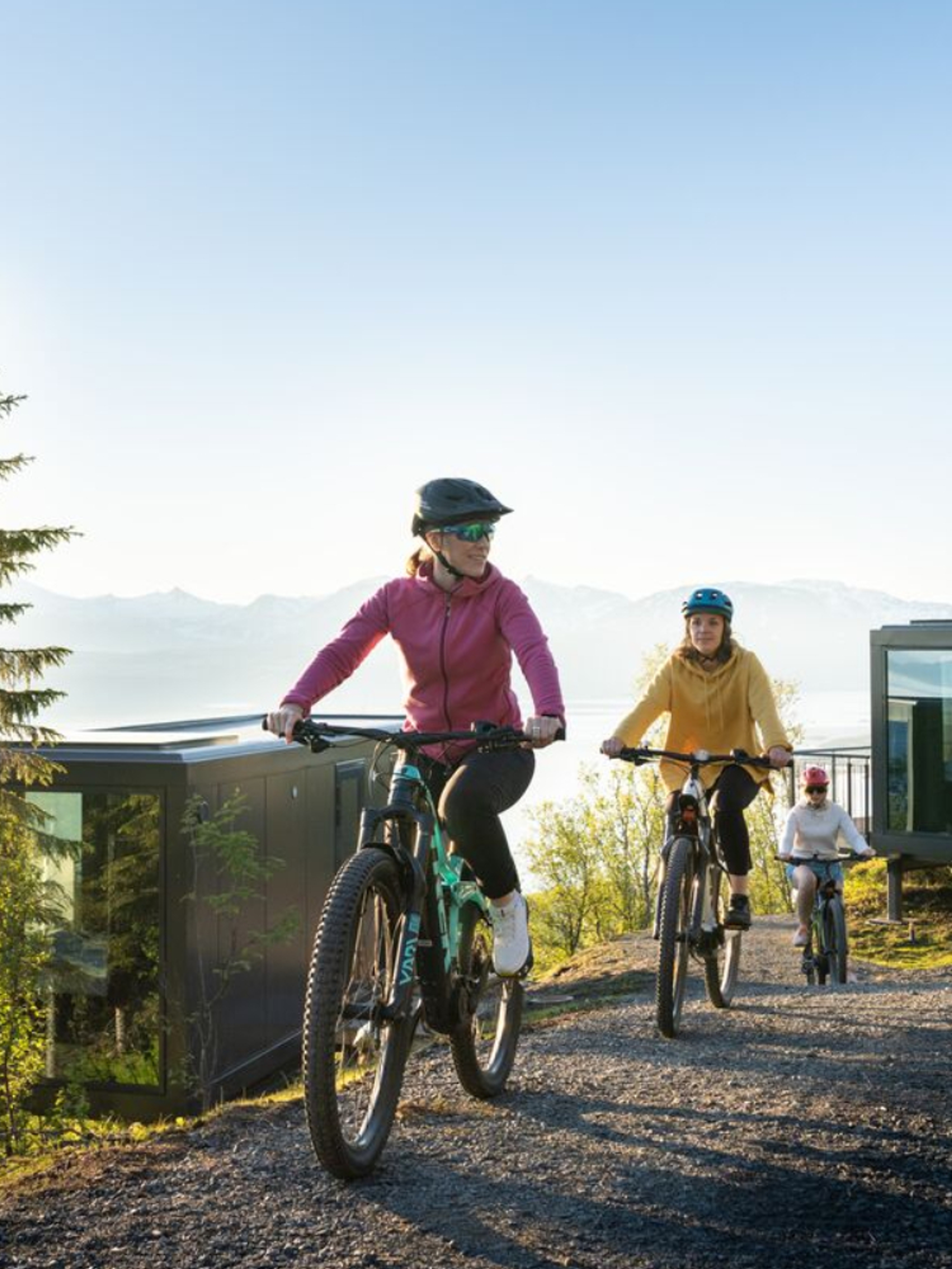 Three people summer biking at the Narvikfjellet with midnight sun