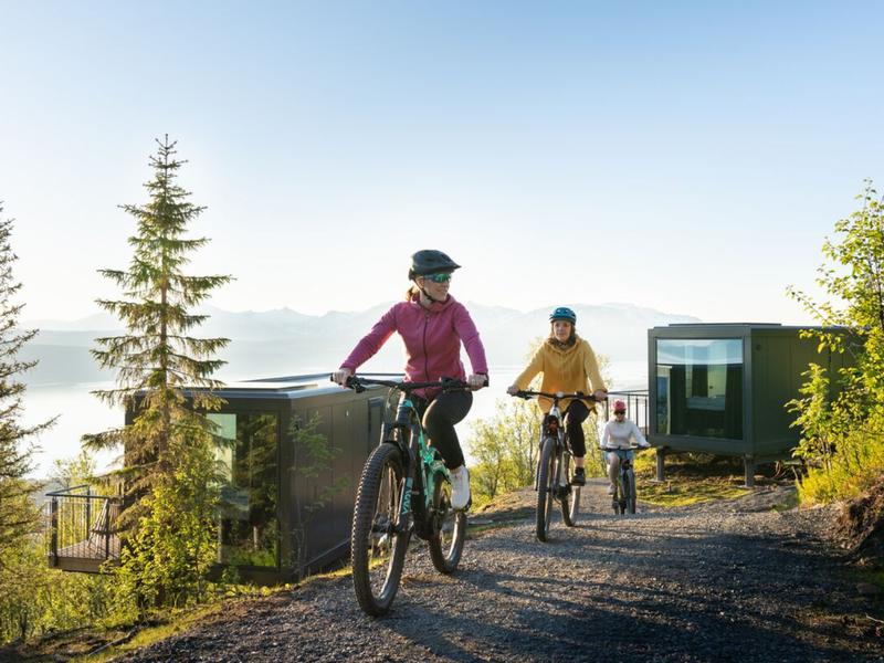 Three people summer biking at the Narvikfjellet with midnight sun