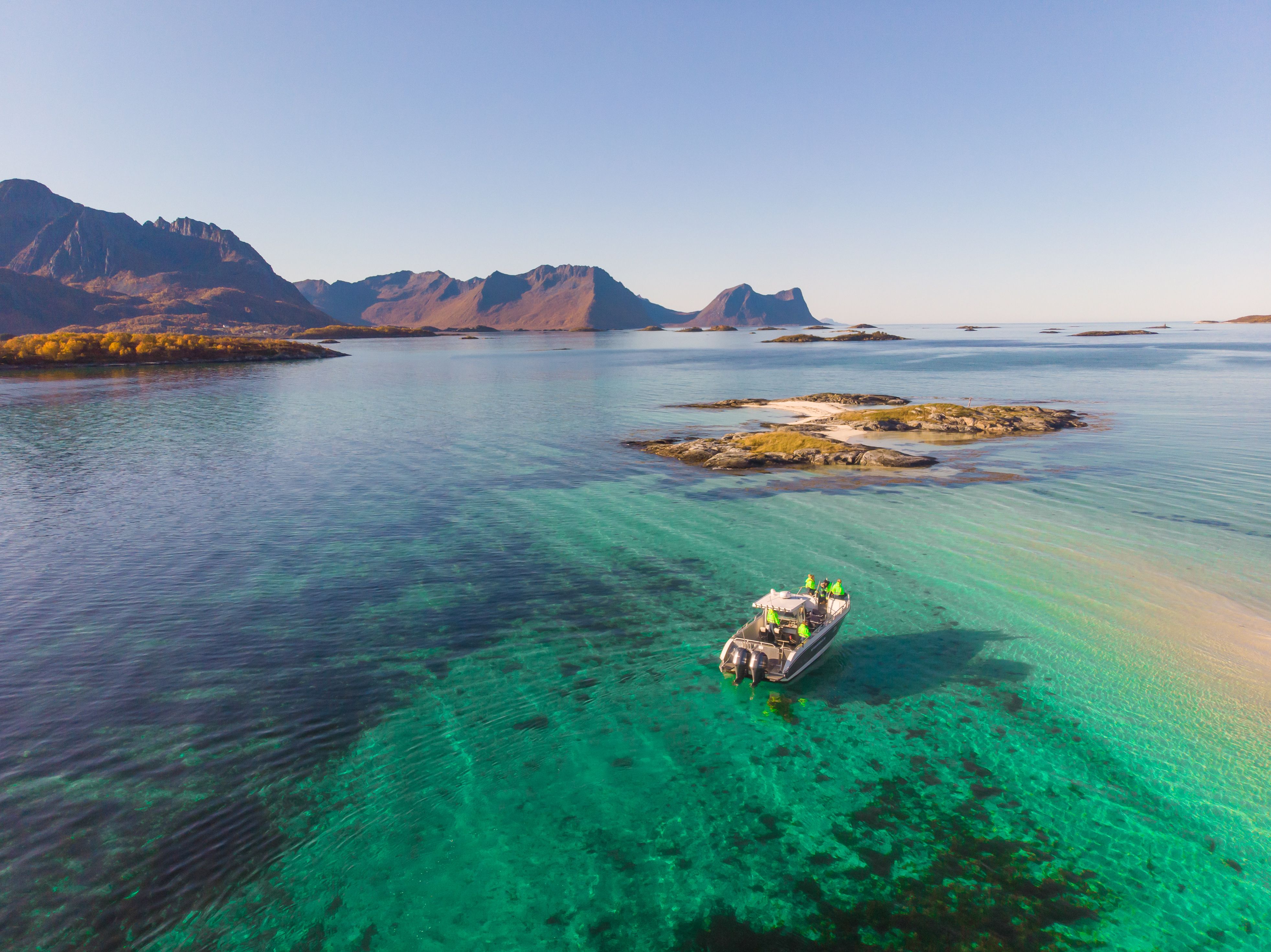A boat out fishing in the turquoise waters in Senja