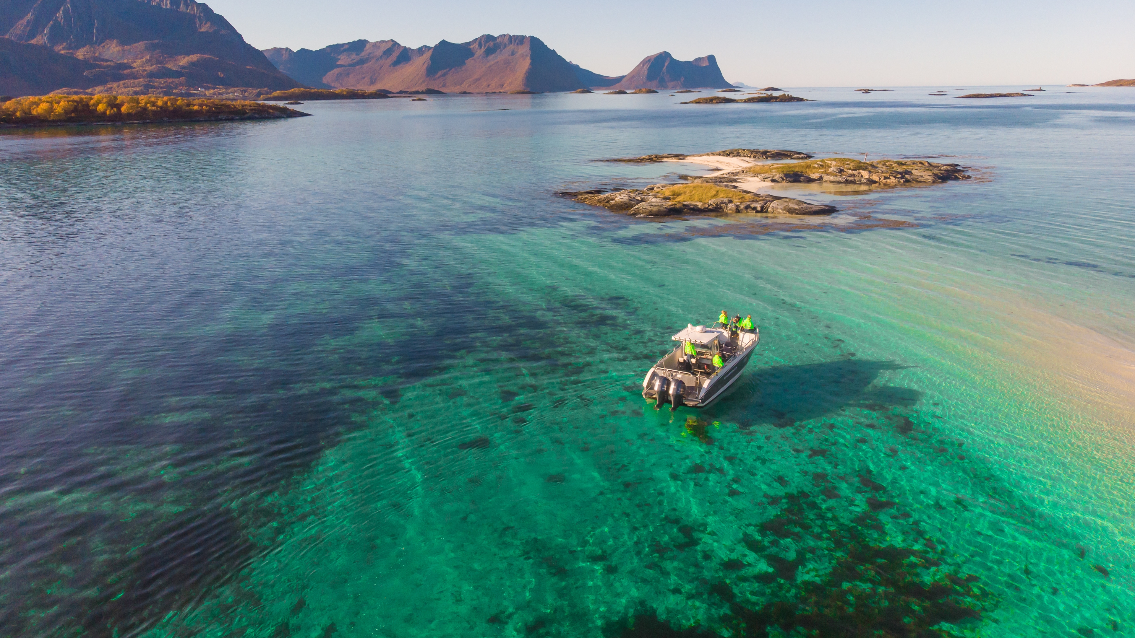 A boat out fishing in the turquoise waters in Senja