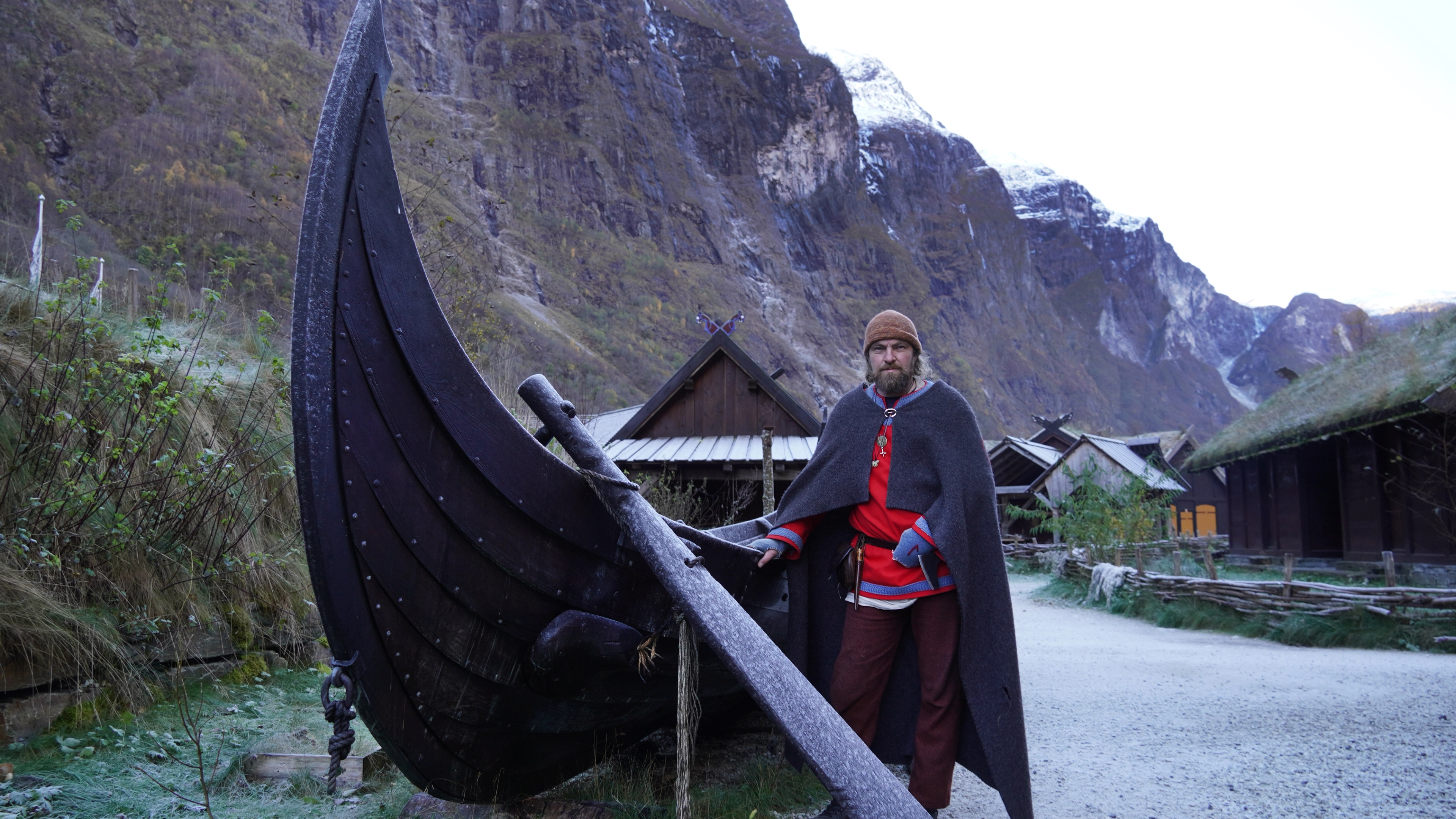 En viking foran et vikingskip i vikingbyen i Gudvangen