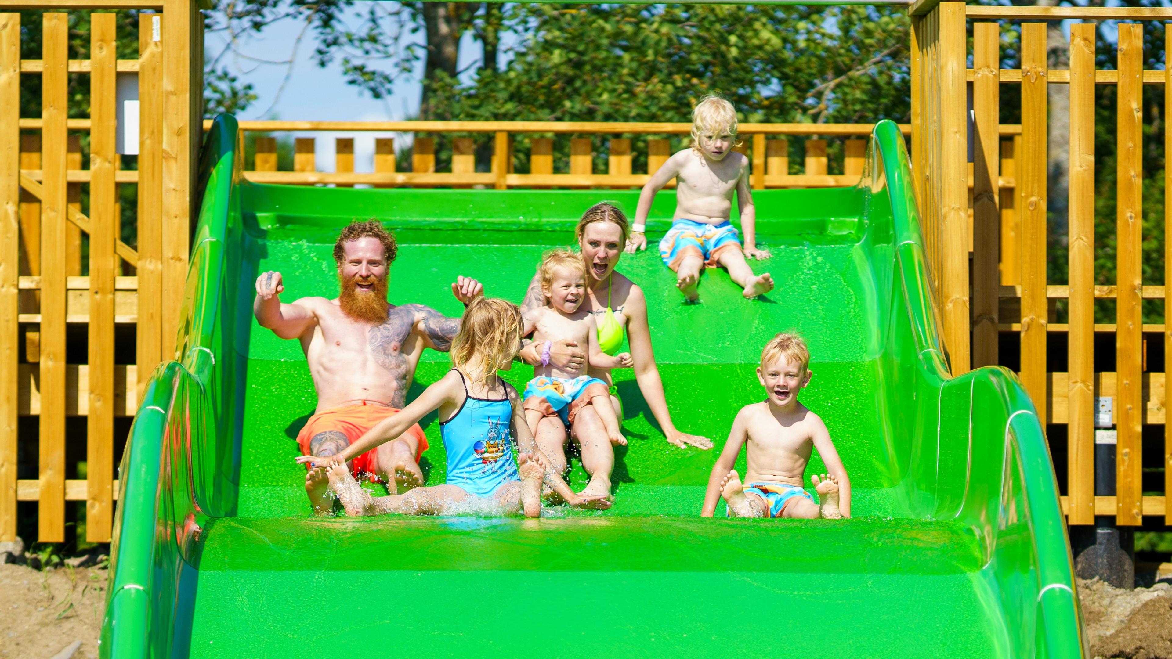 A Family slides down a slide at Foldvik Family Park