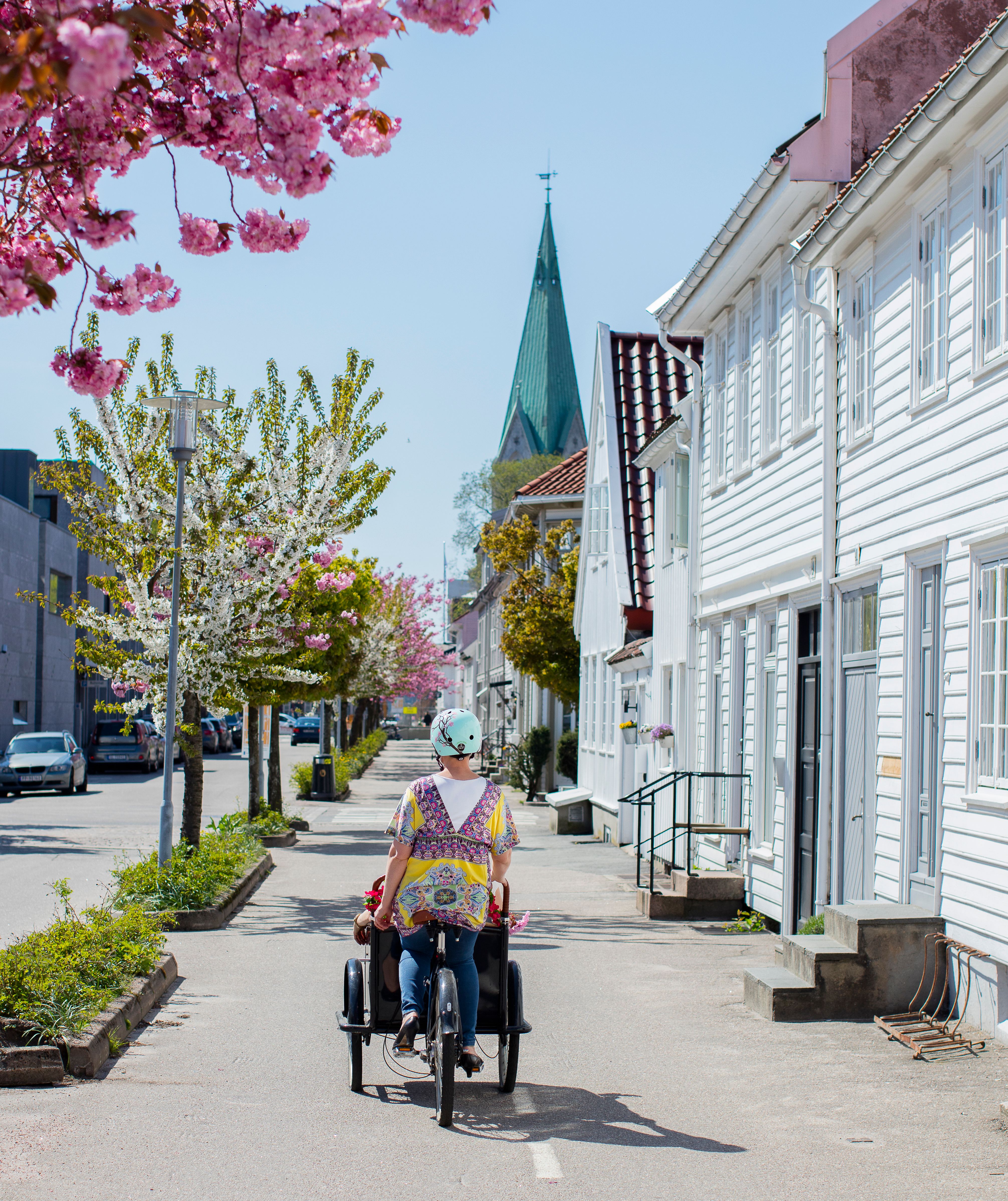 A woman cycling away from the camera in Posebyen in Kristiansand, Southern Norway