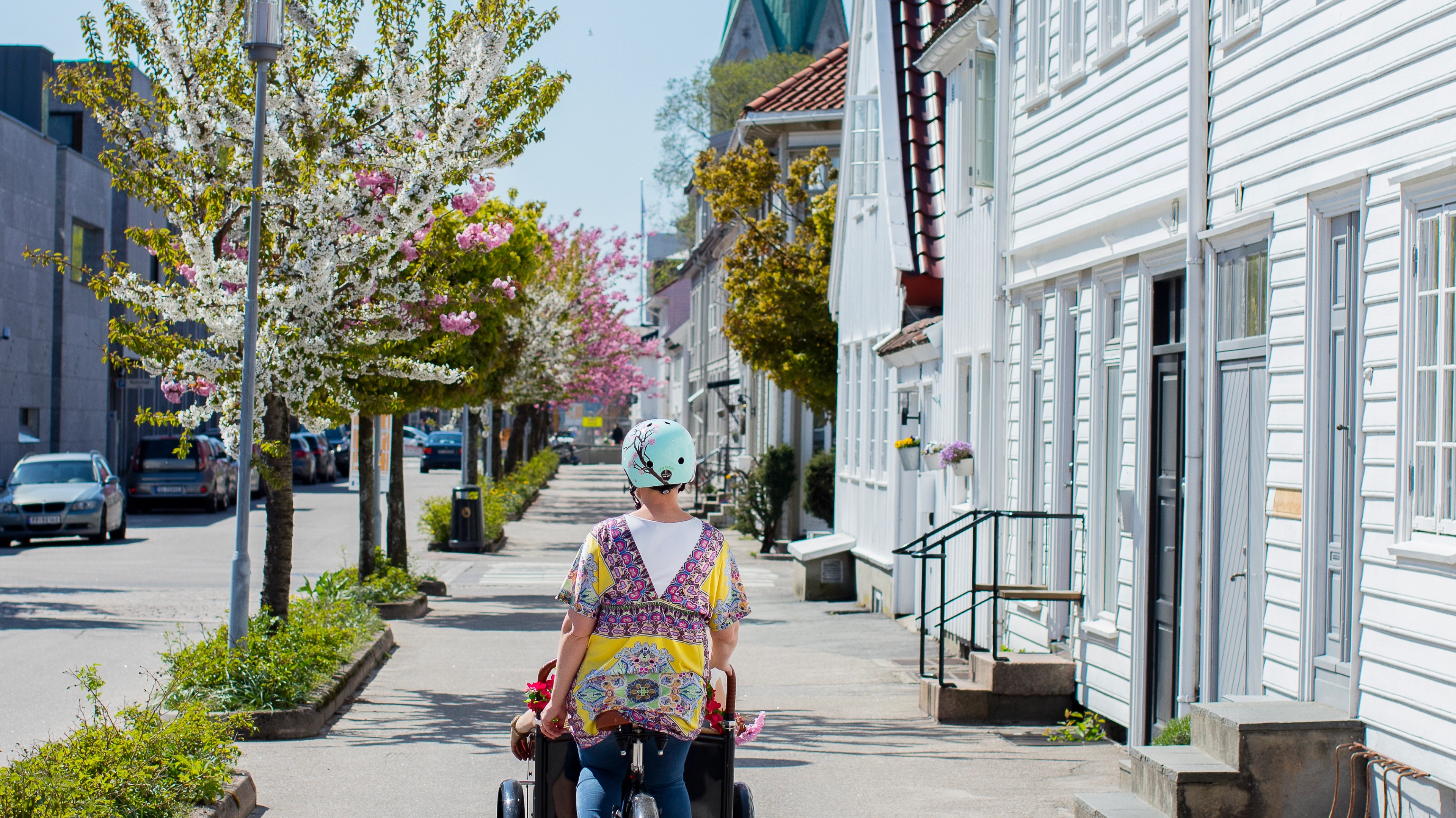 A woman cycling away from the camera in Posebyen in Kristiansand, Southern Norway
