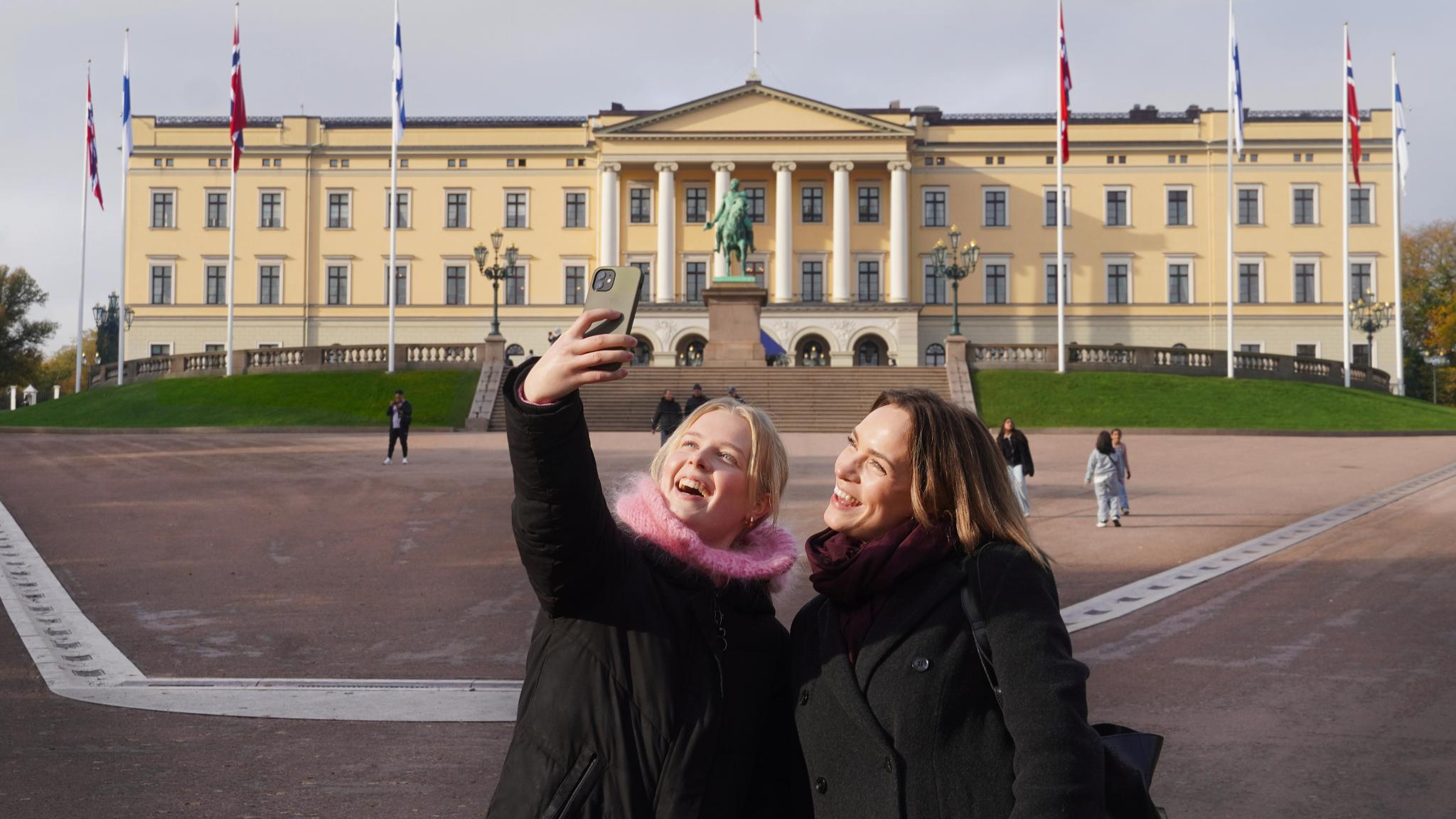Two girls taking a selfie in front of the Norwegian castle in Oslo, Eastern Norway