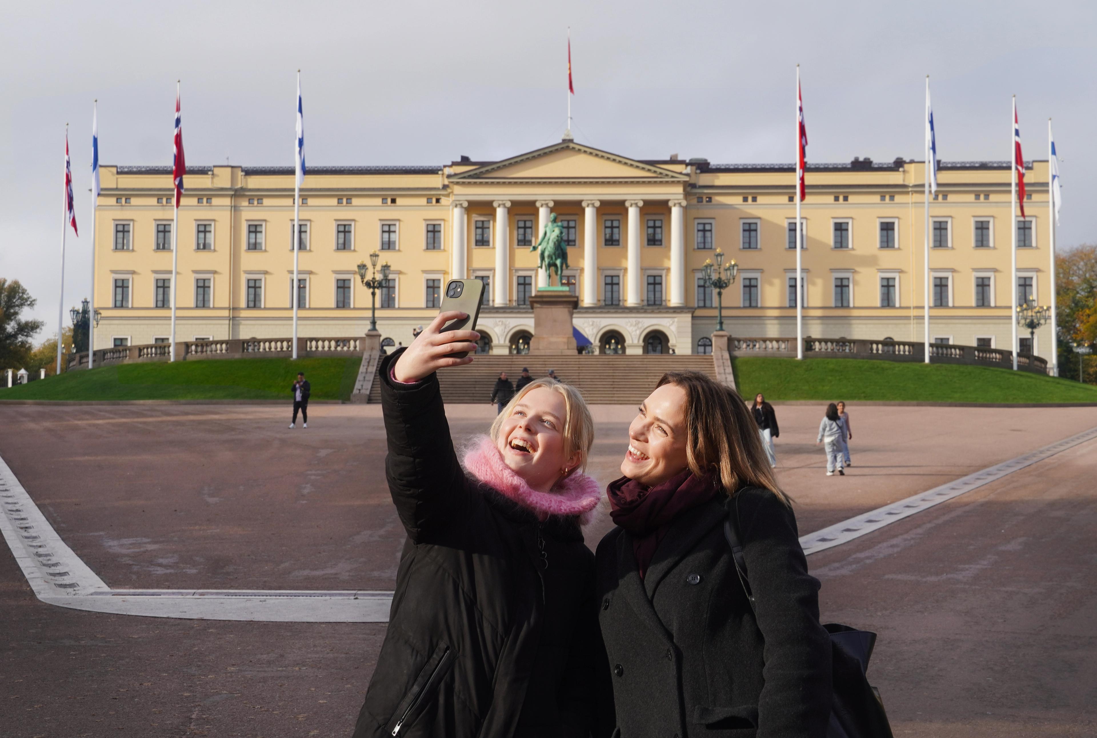 Two girls taking a selfie in front of the Norwegian castle in Oslo, Eastern Norway